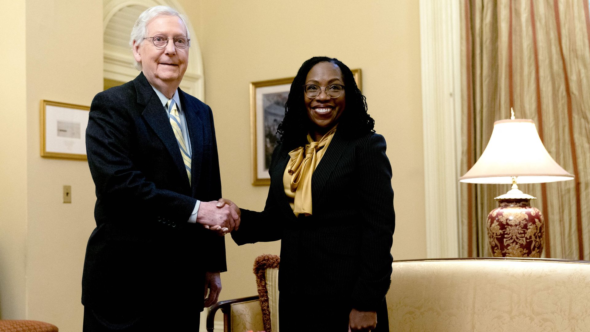 Senate Minority Leader Mitch McConnell is seen shaking hands with Judge Ketanji Brown Jackson.