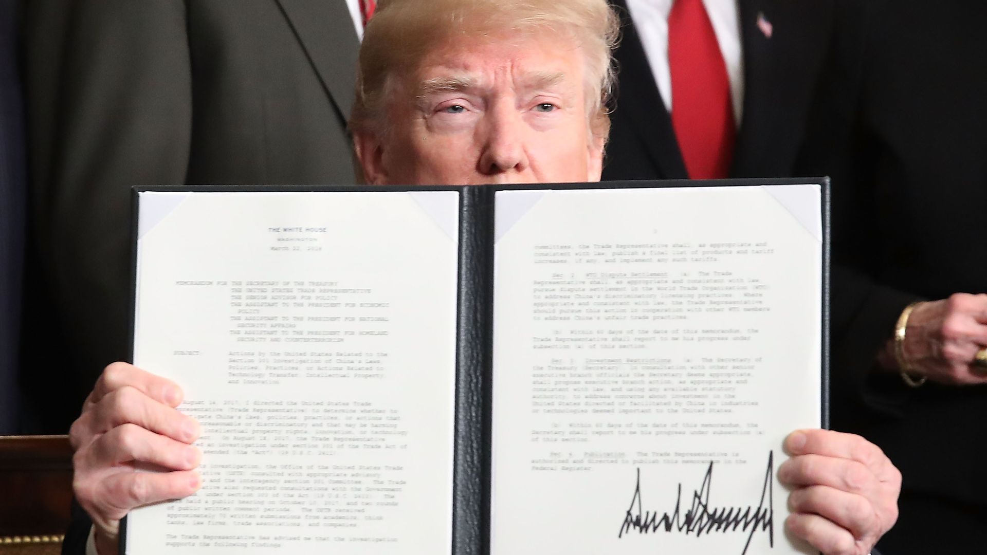 U.S. President Donald Trump holds up a signed presidential memorandum aimed at what he calls Chinese economic aggression in the Roosevelt Room at the White House.