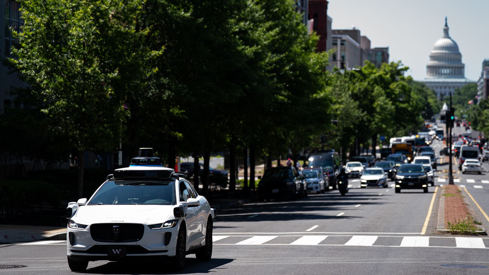 A Waymo test vehicle on a D.C. street with the Capitol in the background