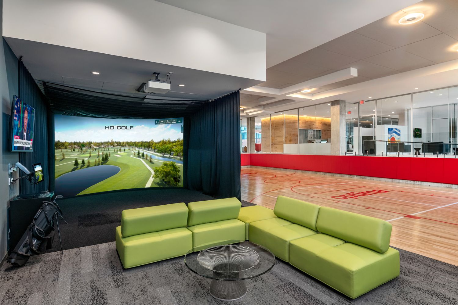 Photo of a basketball court and golf simulator in a lobby 