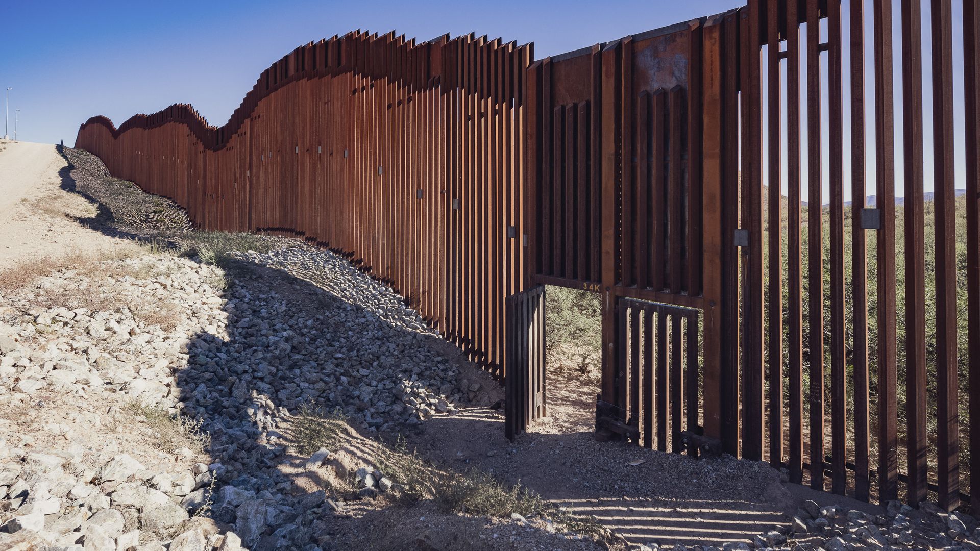 Steel fencing runs through the desert along the United States-Mexico border in Arizona.