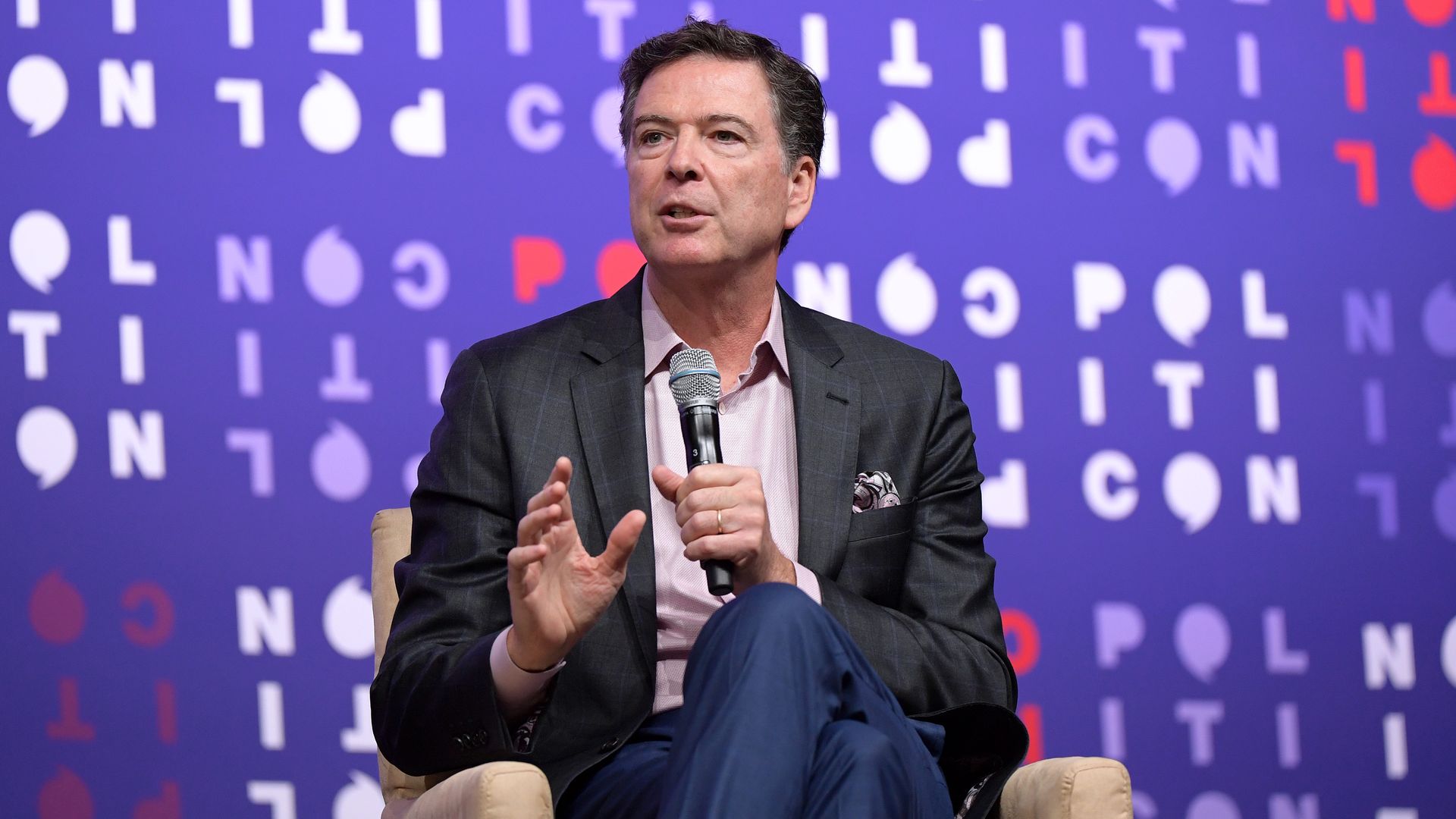 James Comey sits in a chair.
