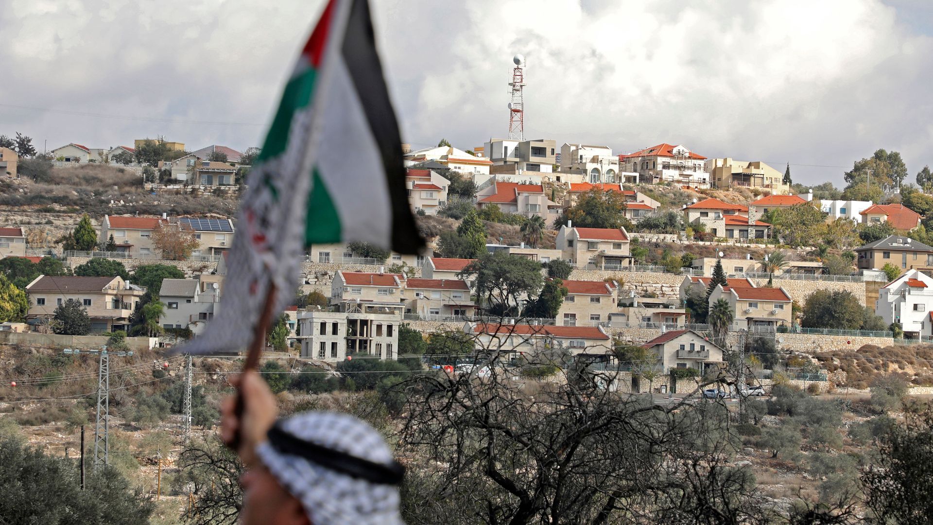 Palestinian protestor waves a flag in the West Bank