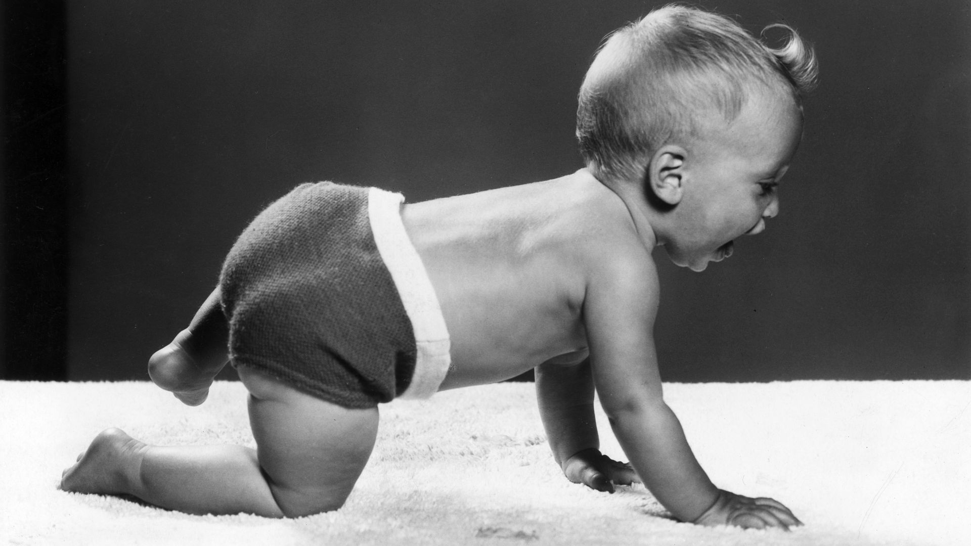 A baby crawls on the carpet