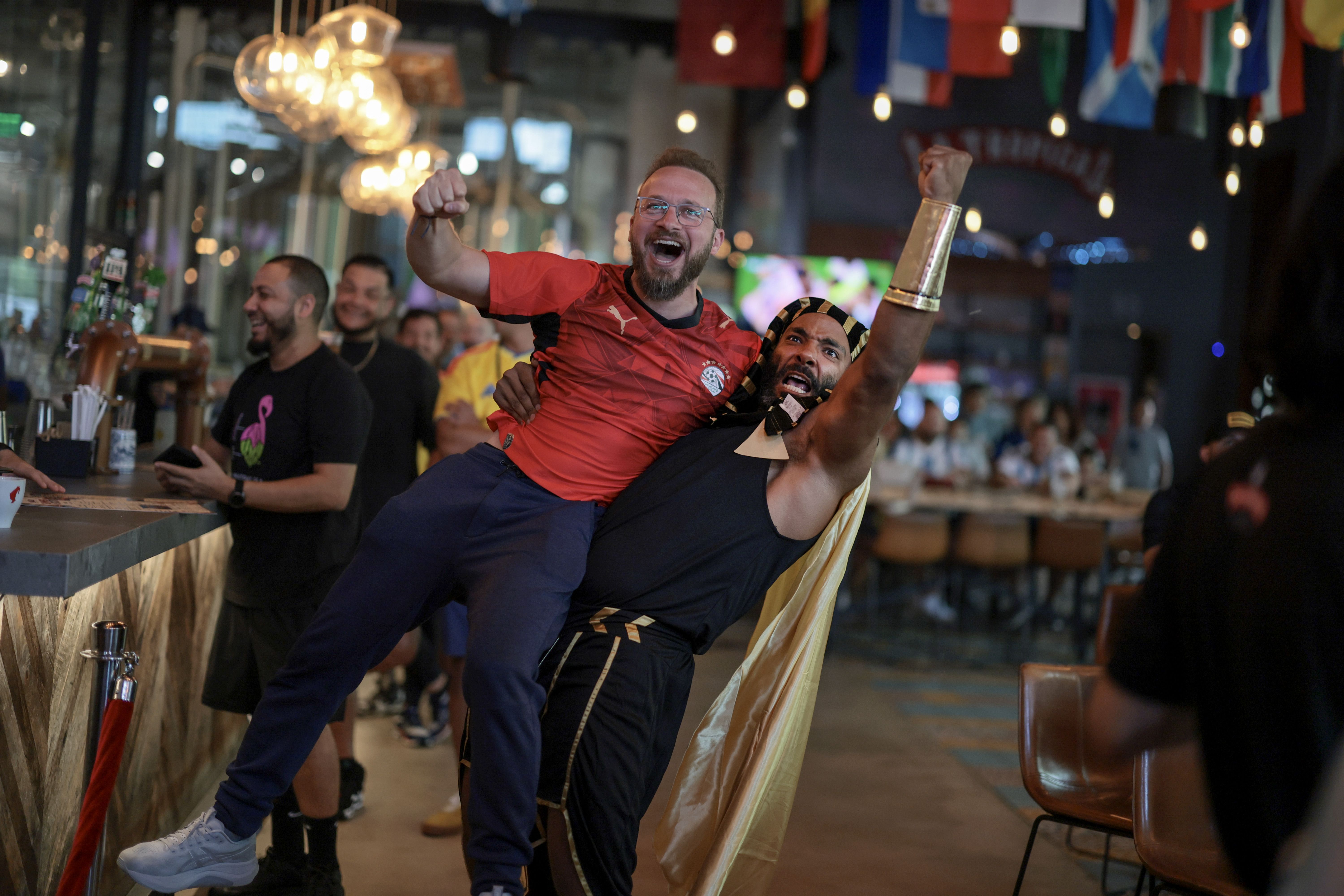 MIAMI, FLORIDA - JULY 07: Ahmed Ibrahim (L) celebrates with Hassan Abbas as the Egyptian team scores against Argentina during a FIFA World Cup match watch party at Cerveceria La Tropica on July 07, 2026, in Miami, Florida. Argentina and Egypt are playing in the round-of-16 match in Atlanta. (Photo b