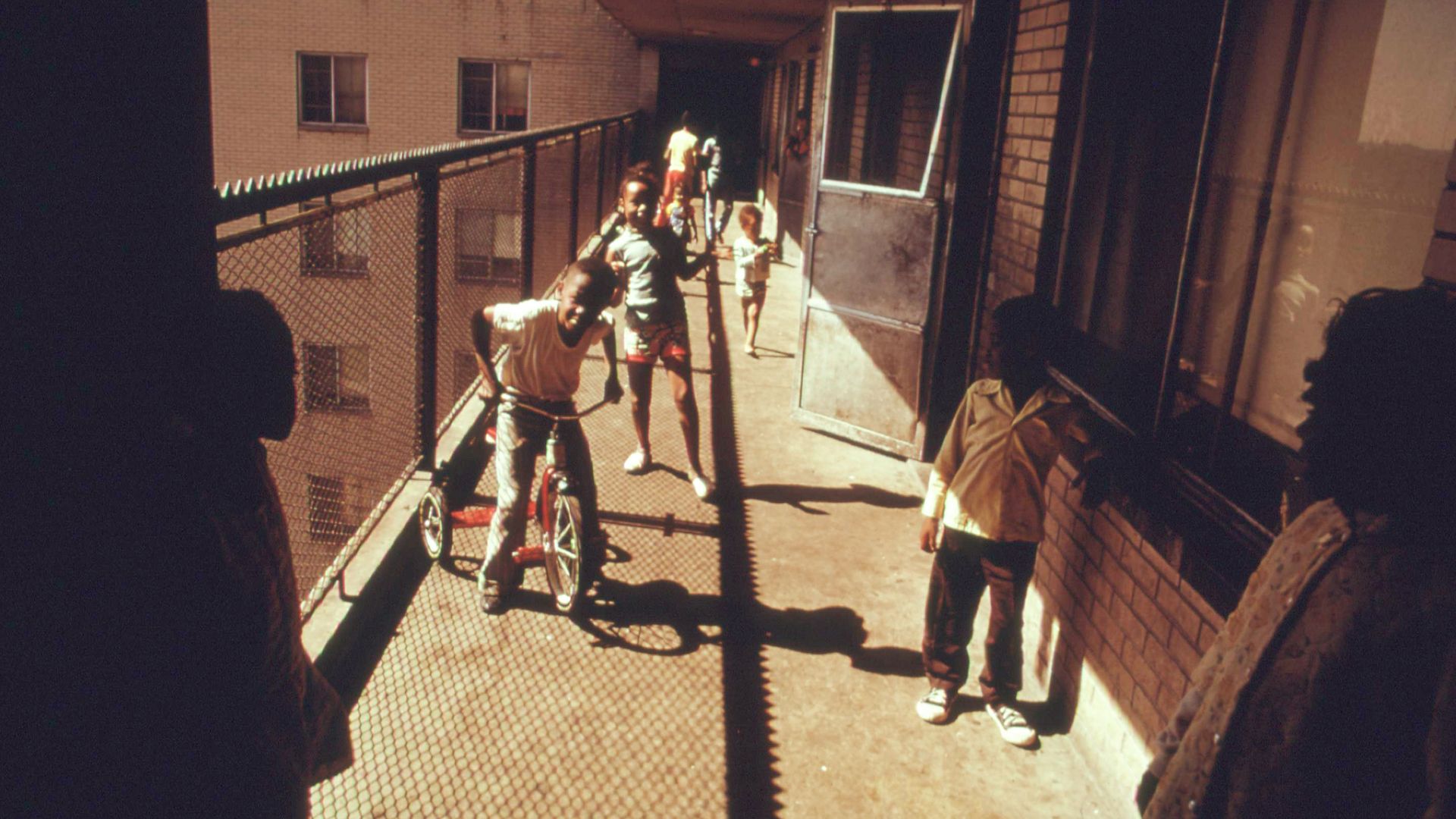 Photo of kids playing on a balcony of a high-rise 