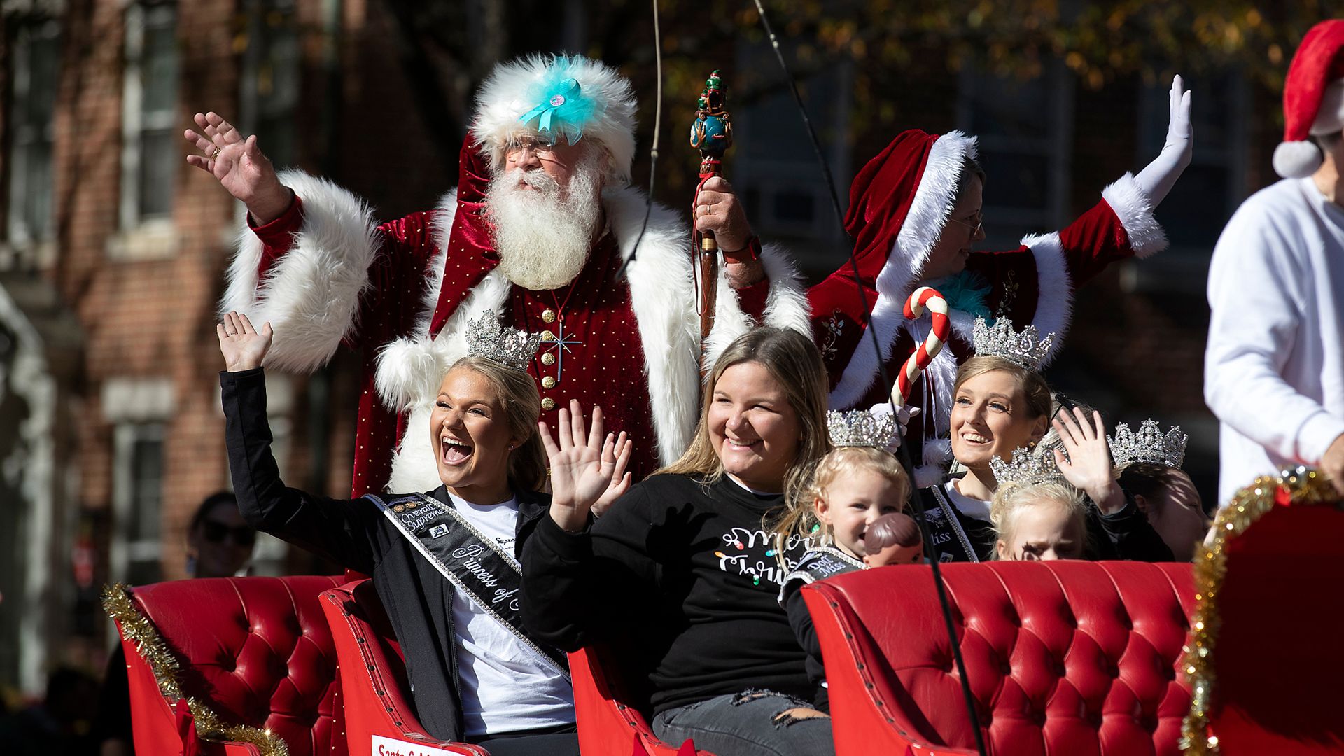 Santa waves from a carriage pulled by horses at the conclusion of the Raleigh Christmas Parade