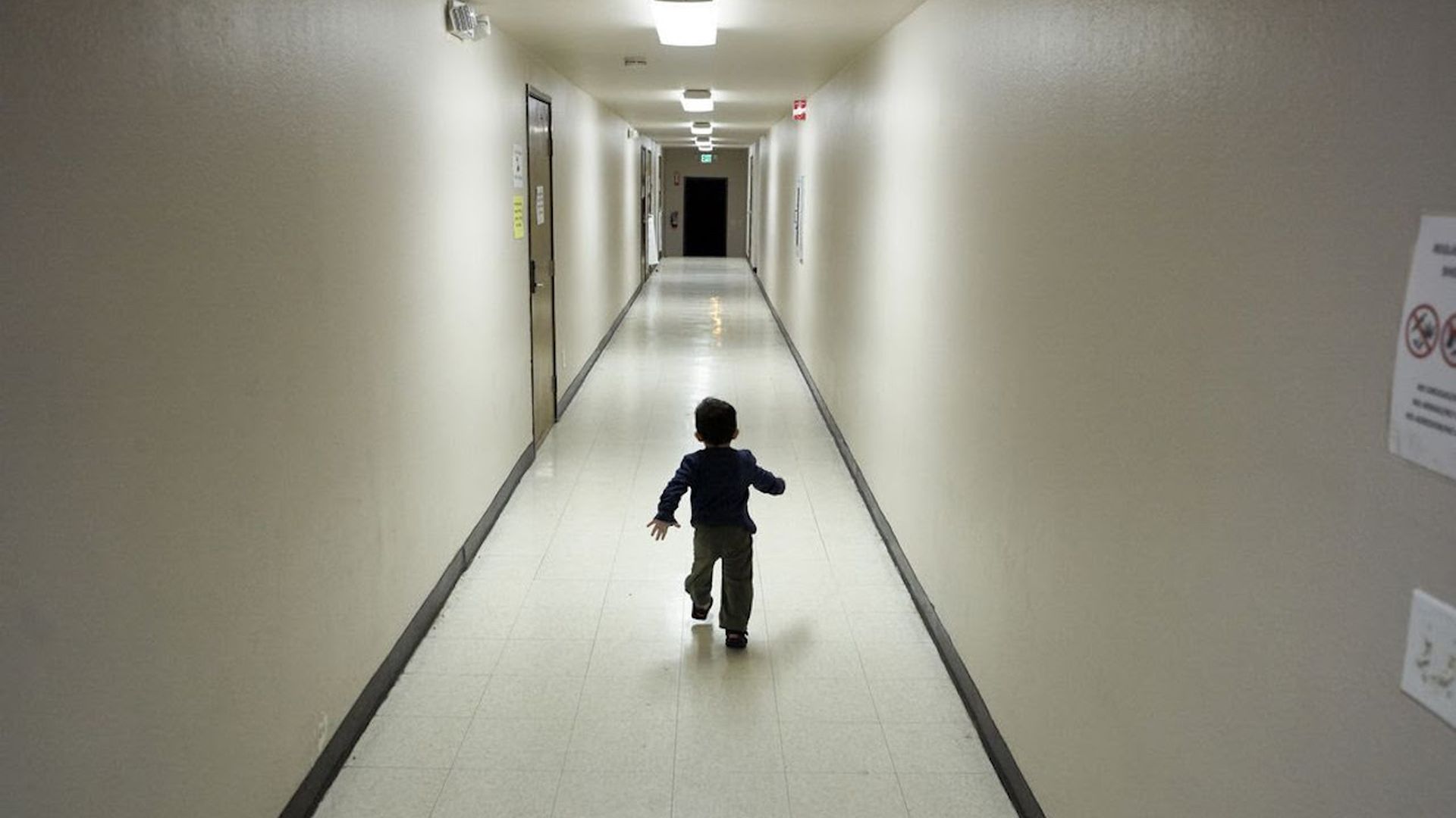 A child running down an empty hallway