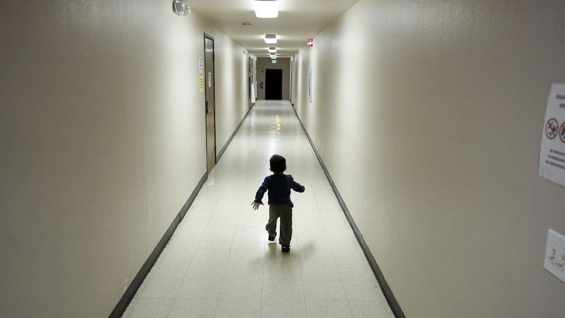 A child running down an empty hallway