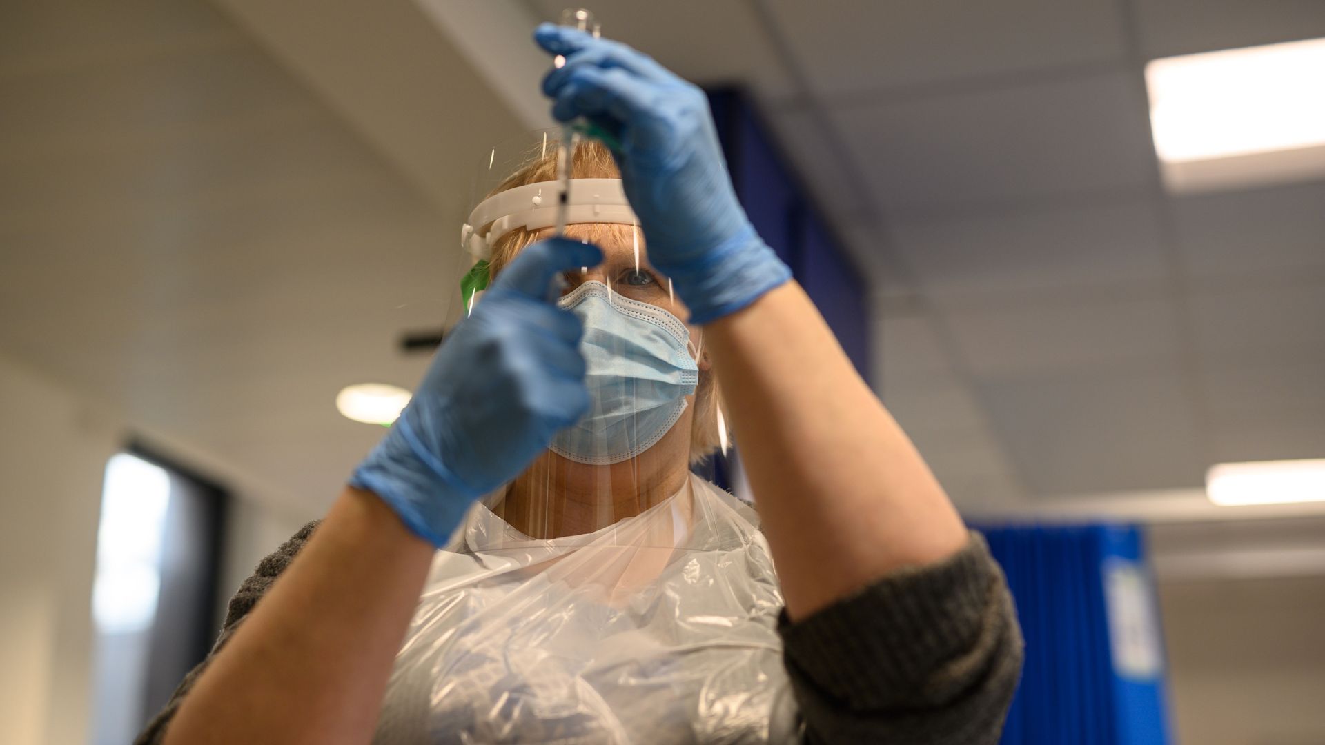 A volunteer draws a solution into a syringe as she practices intramuscular injections during vaccinator training to prepare volunteers to be deployed.