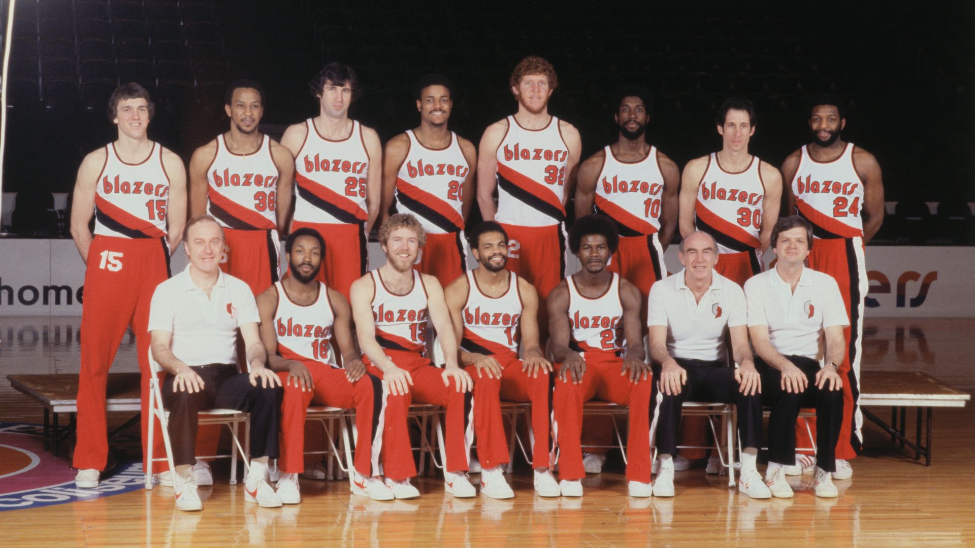 The 1977 Portland Trail Blazers team poses for a picture on a basketball court.