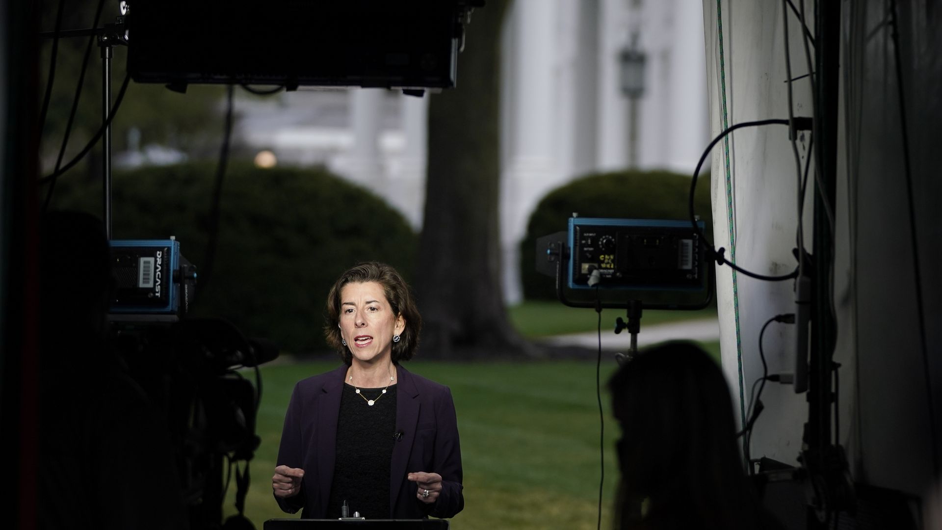 Commerce Secretary Gina Raimondo is seen giving a TV interview from the front lawn of the White House.