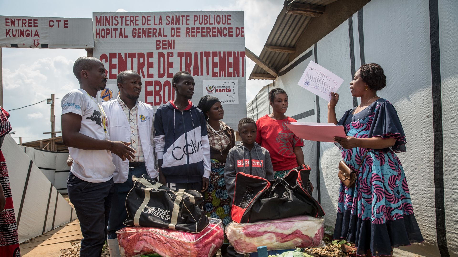 Photo of 8 year old getting certificate outside an Ebola Treatment Center in Congo declaring he is Ebola free