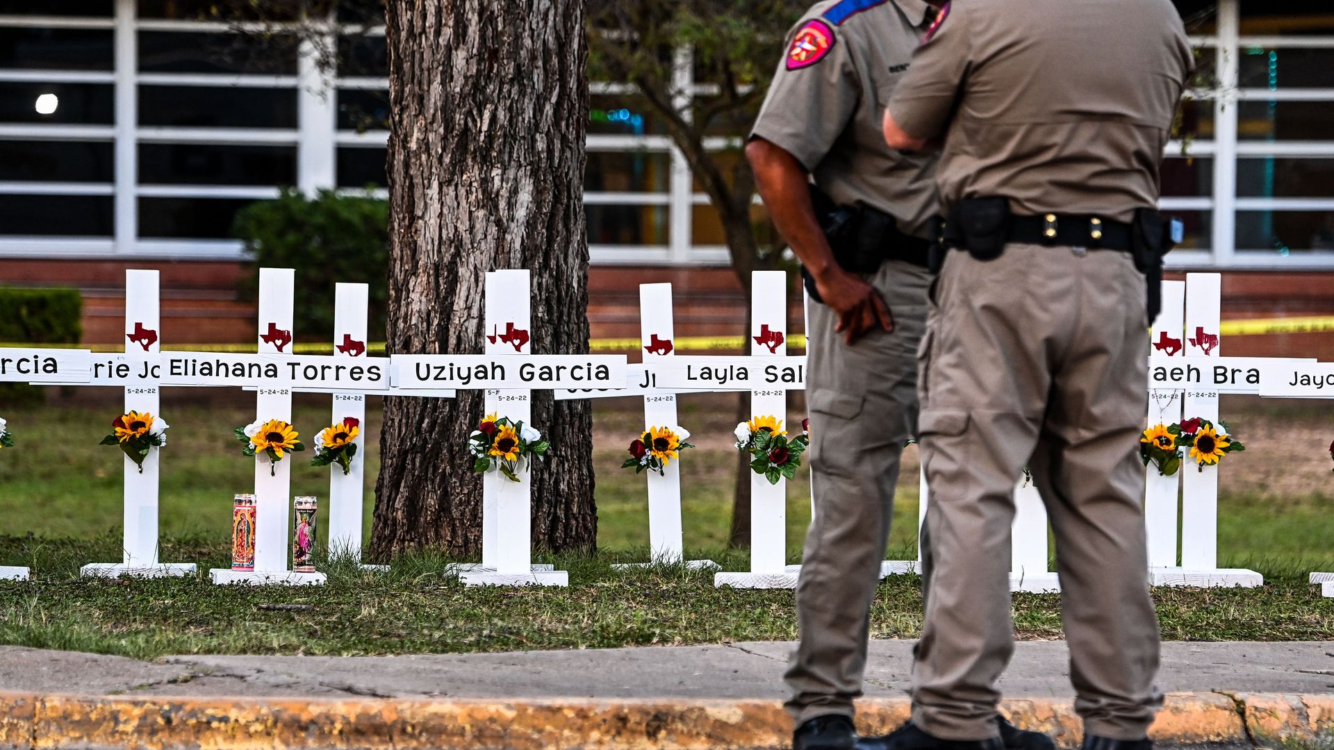 Police officers stand near a makeshift memorial for the shooting victims at Robb Elementary School in Uvalde, Texas.
