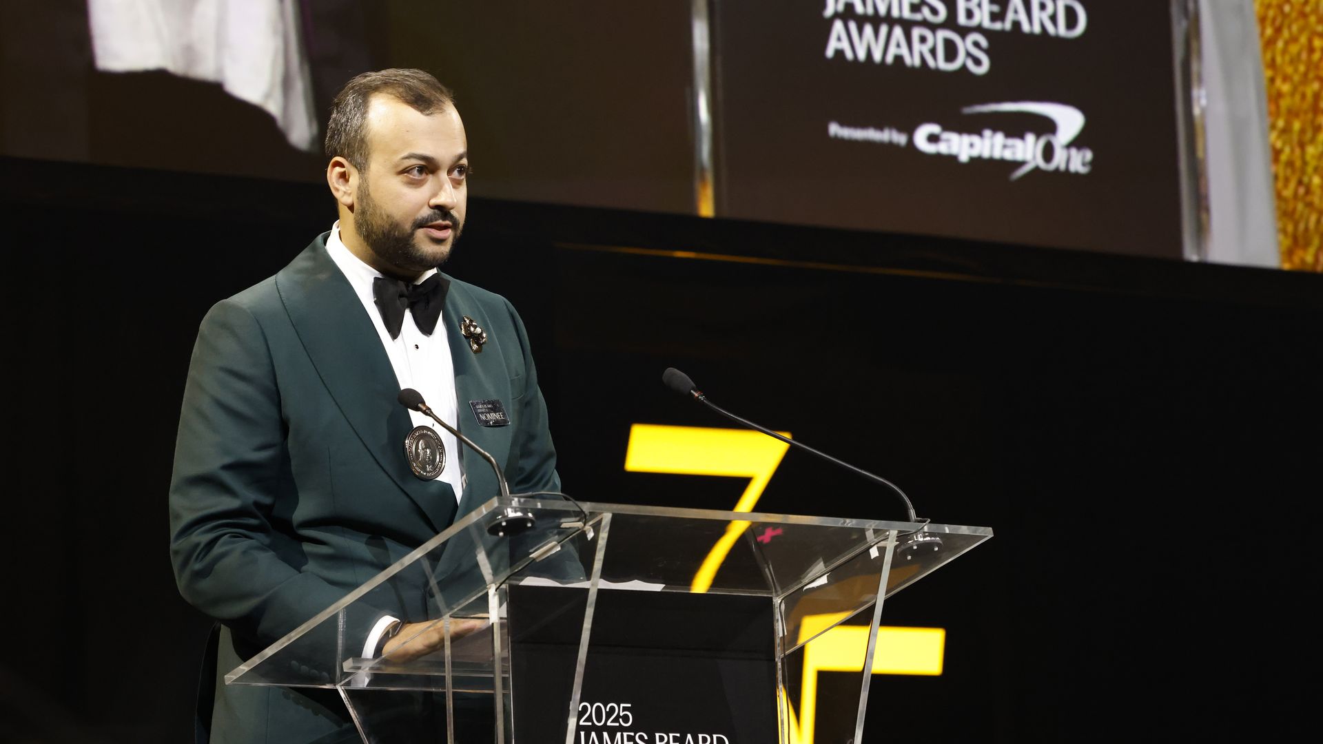 Arjav Ezekiel stands at a clear podium at the James Beard Awards in Chicago