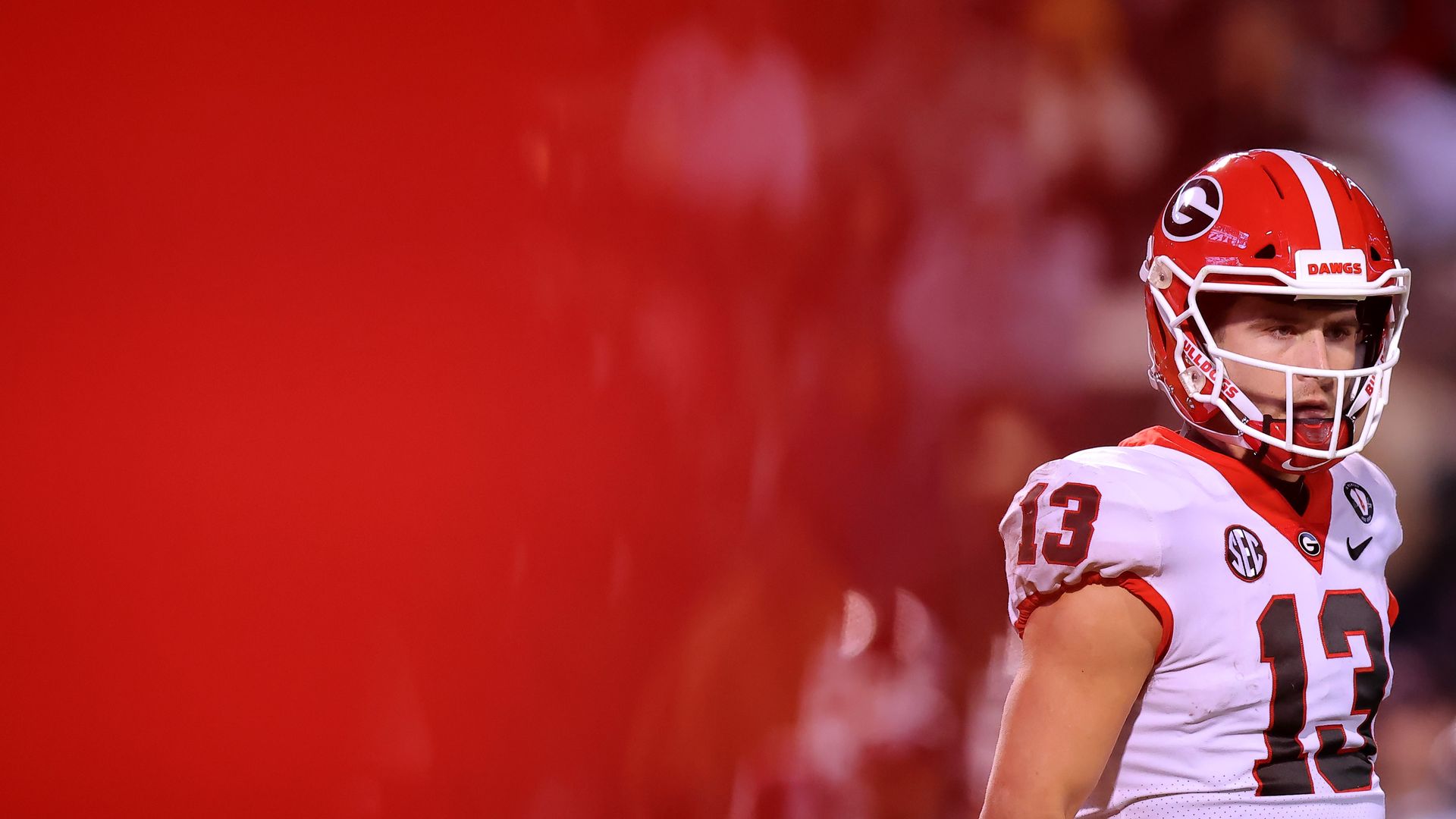 Stetson wearing a full football uniform walks along the field during a game