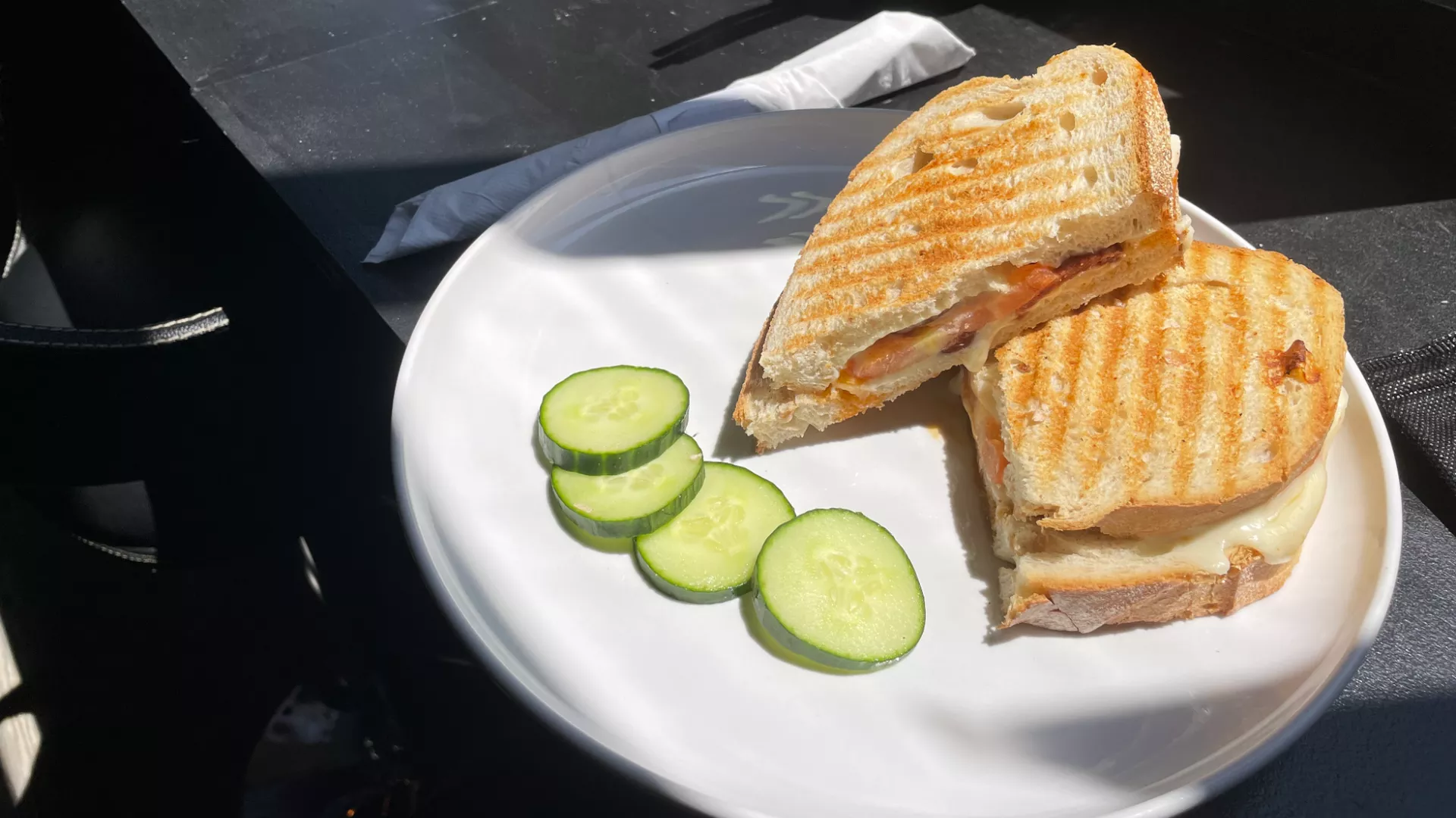 A sandwich with sliced cucumbers on a plate