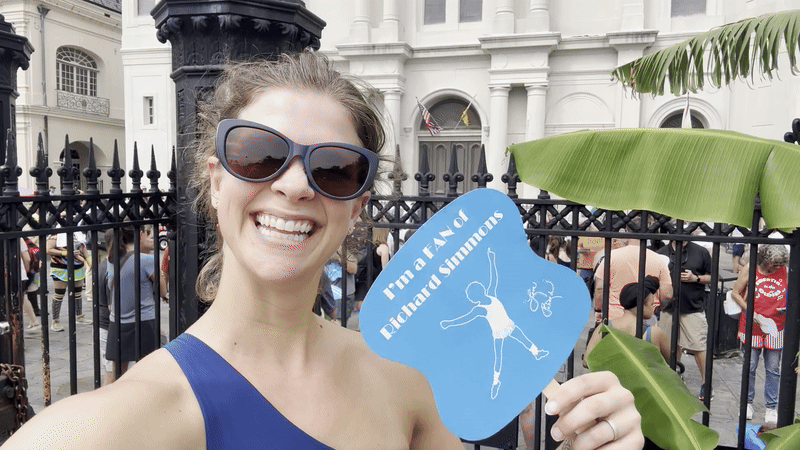 A woman waves a fan toward herself.