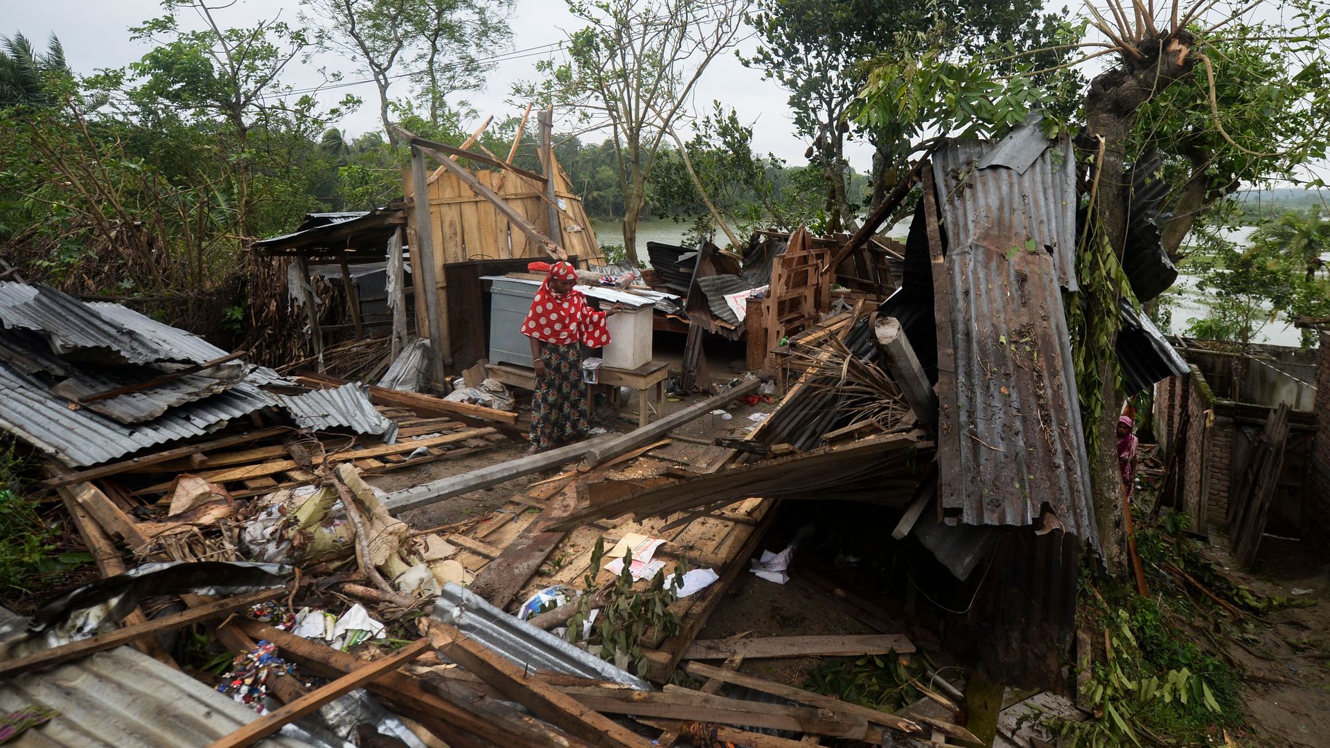  A woman stands amidst the debris of her house damaged by cyclone Amphan in Satkhira on May 21