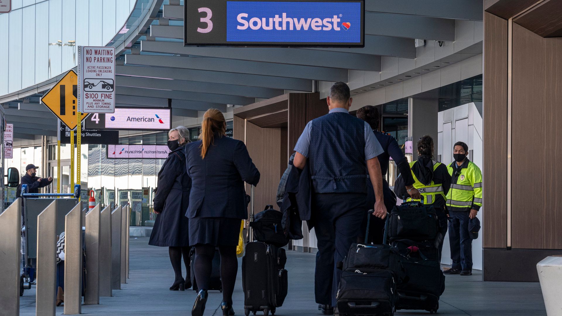 Picture of two people walking underneath a blue "Southwest" terminal sign