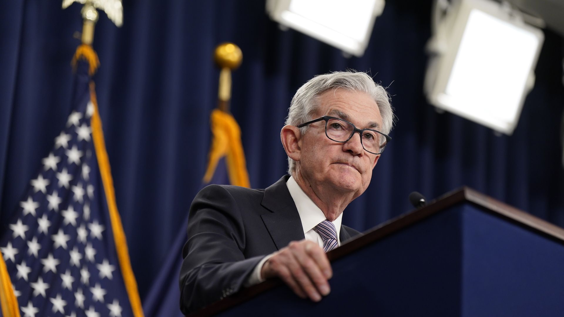 Fed chairman Jerome Powell stands at a podium at a news conference 