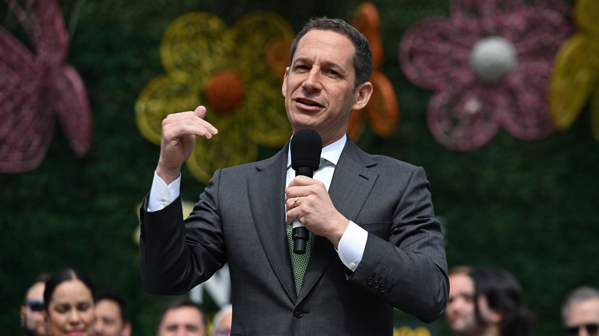 Photo of Daniel Lurie speaking with a microphone while smiling
