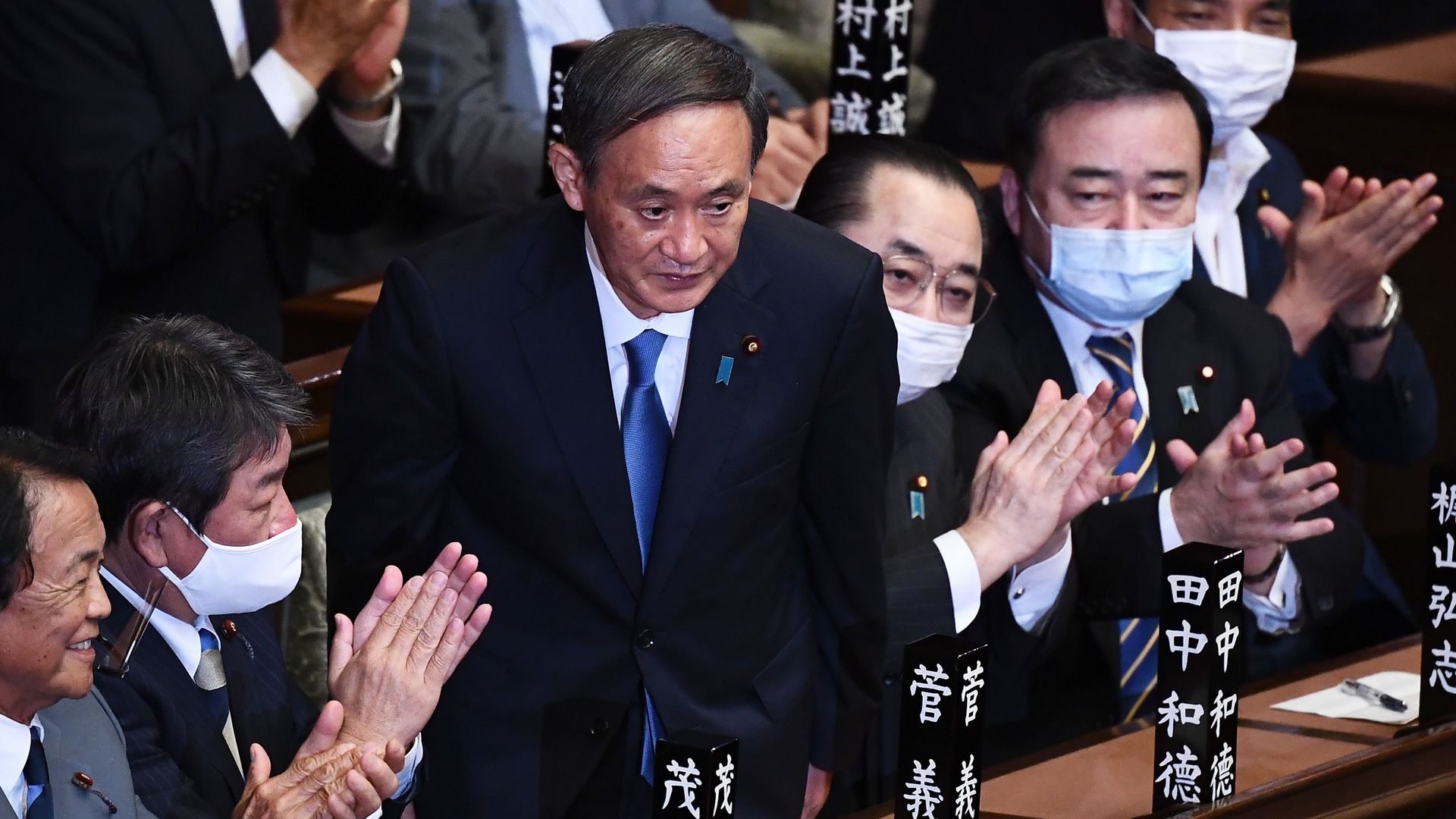 Newly elected leader of Japan's Liberal Democratic Party (LDP) Yoshihide Suga (C) is applauded after he was elected as Japan's prime minister