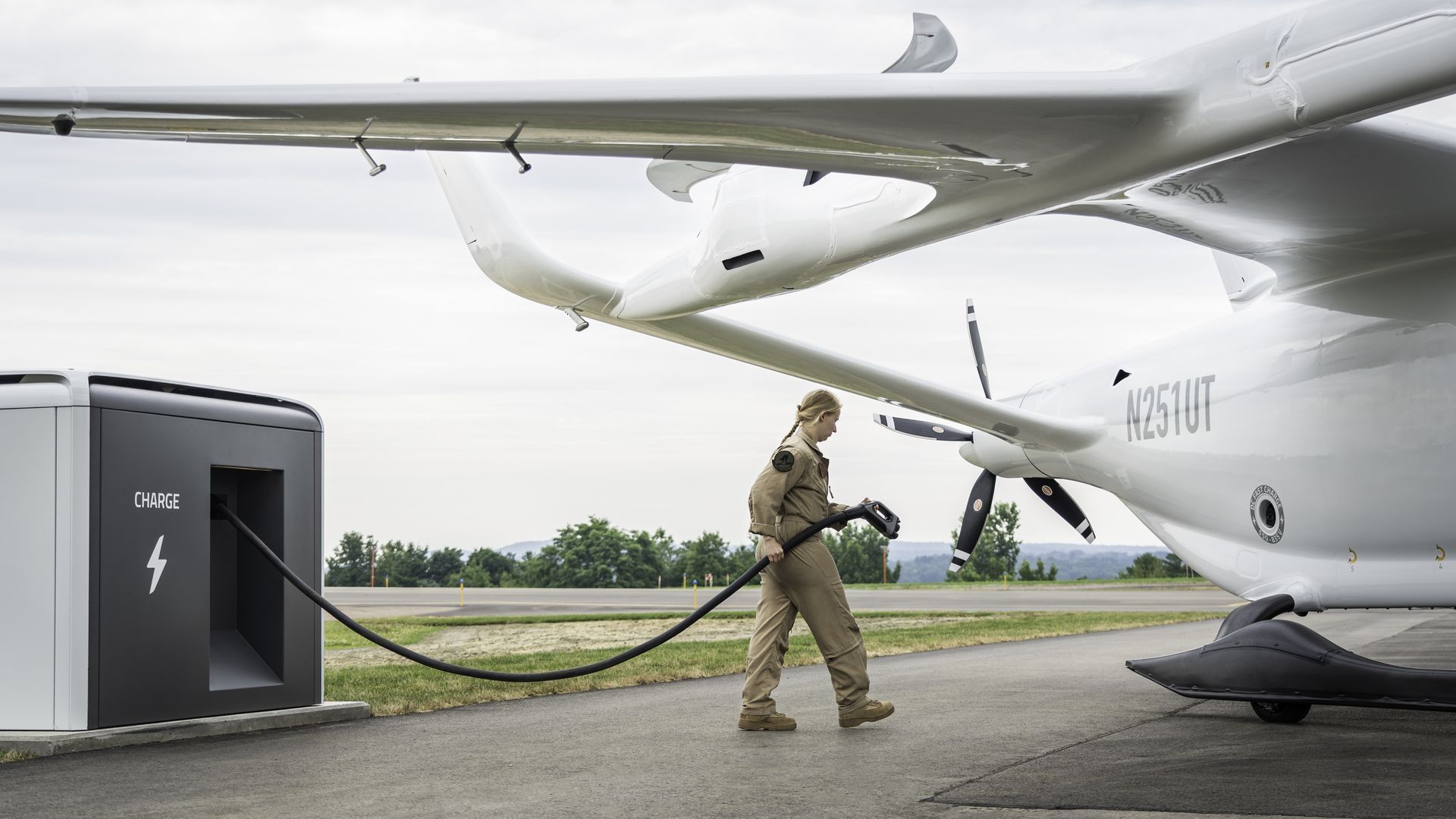 Image of a female flight test engineer plugging in an electric BETA plane
