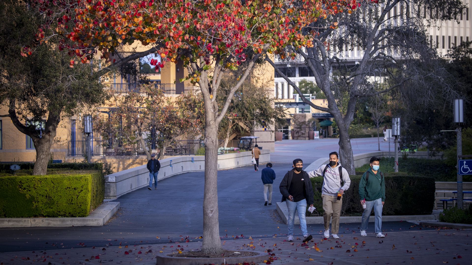 Students, faculty and others walk down a campus path amidst a mostly empty University of California-Irvine campus Friday, Jan. 7, 2022.