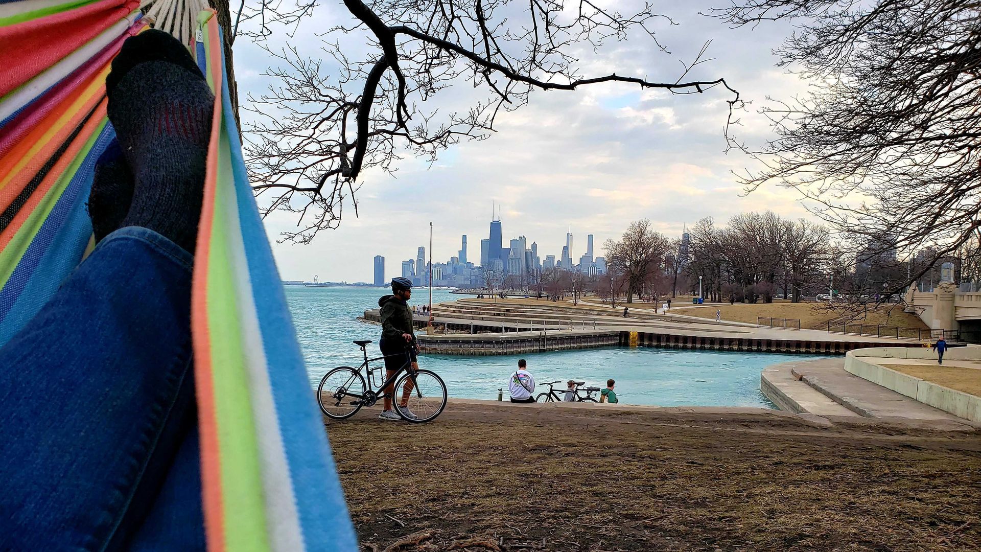 Photo of a woman in a hammock in front of a city skyline. 