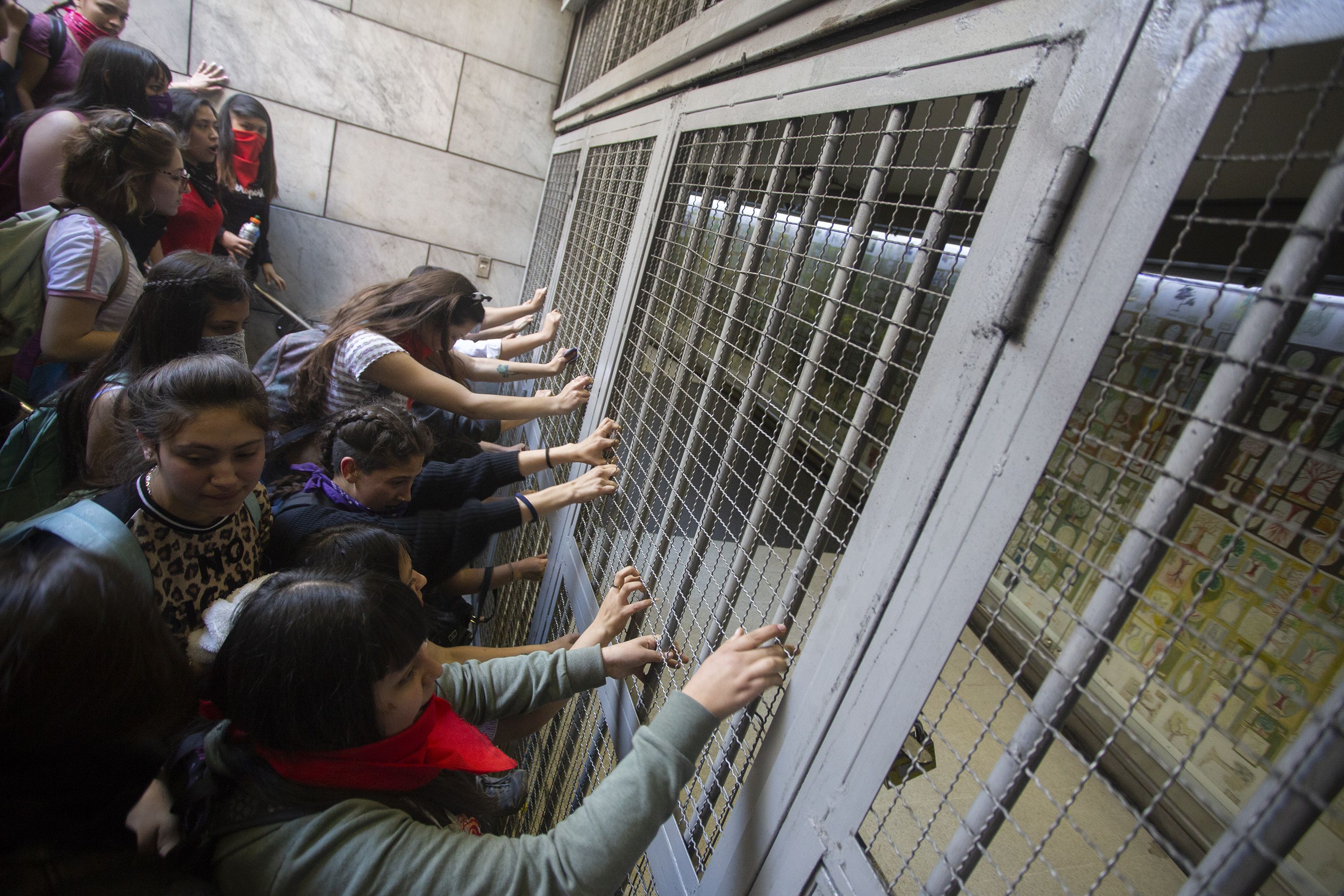 In this image, a line of protestors grab onto a metro grate 