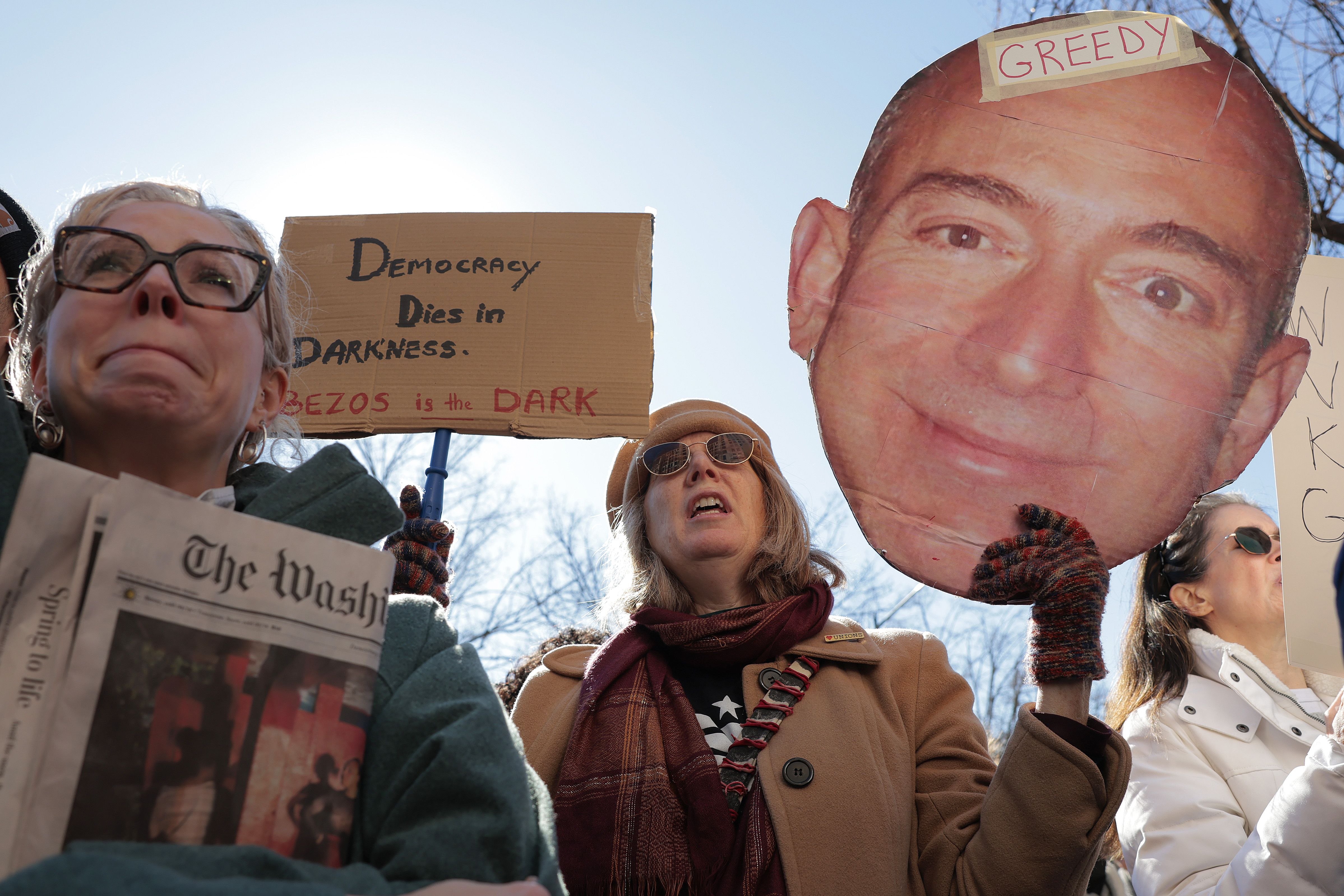 Local D.C. residents who read the Washington Post joined members of the guild to protest during a rally outside the Washington Post office building on February 05, 2026 in Washington, DC. The Washington Post, owned by billionaire Amazon founder Jeff Bezos, announced major job cuts on February 4, lay