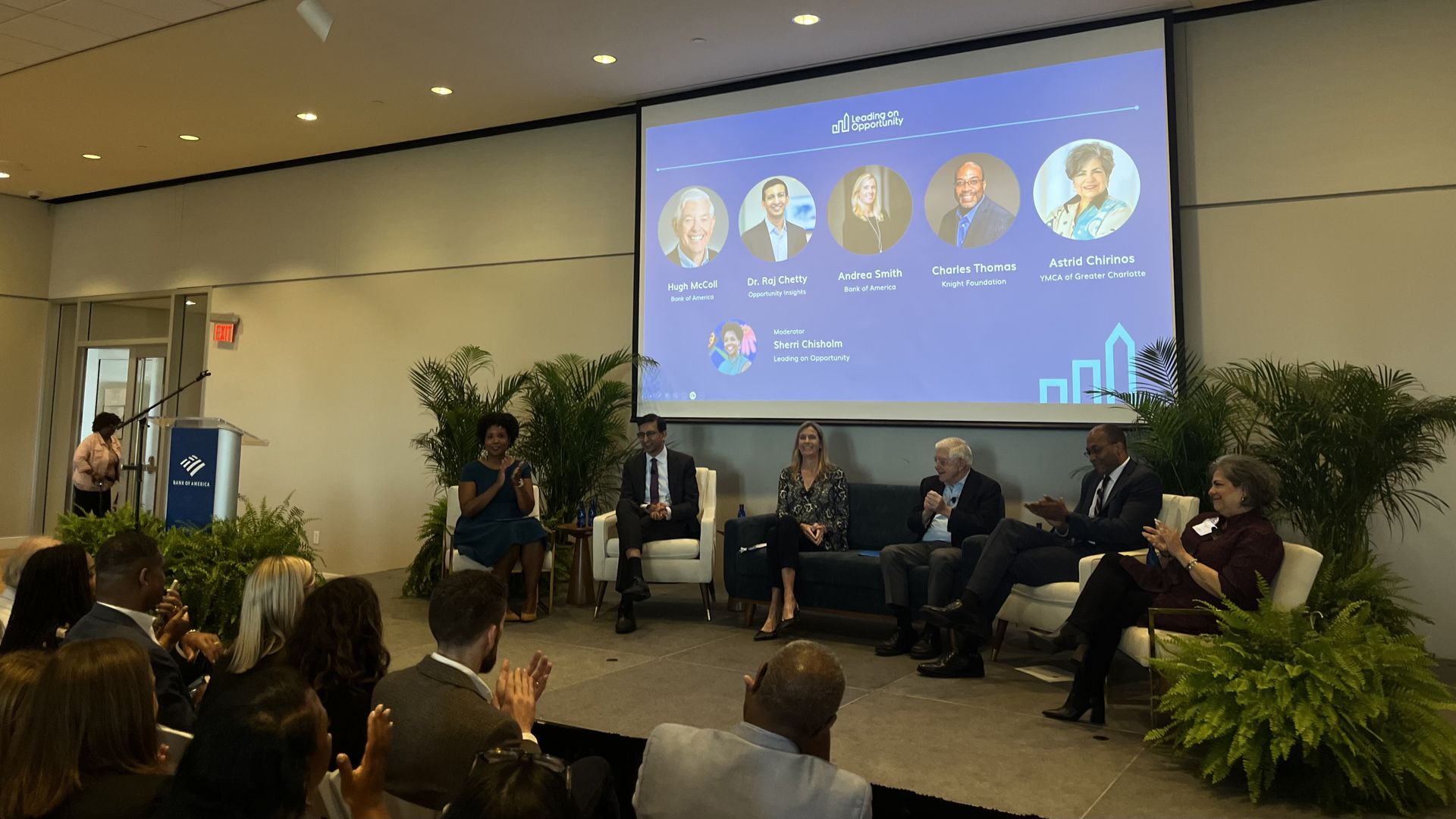 A panel of people sit in chairs