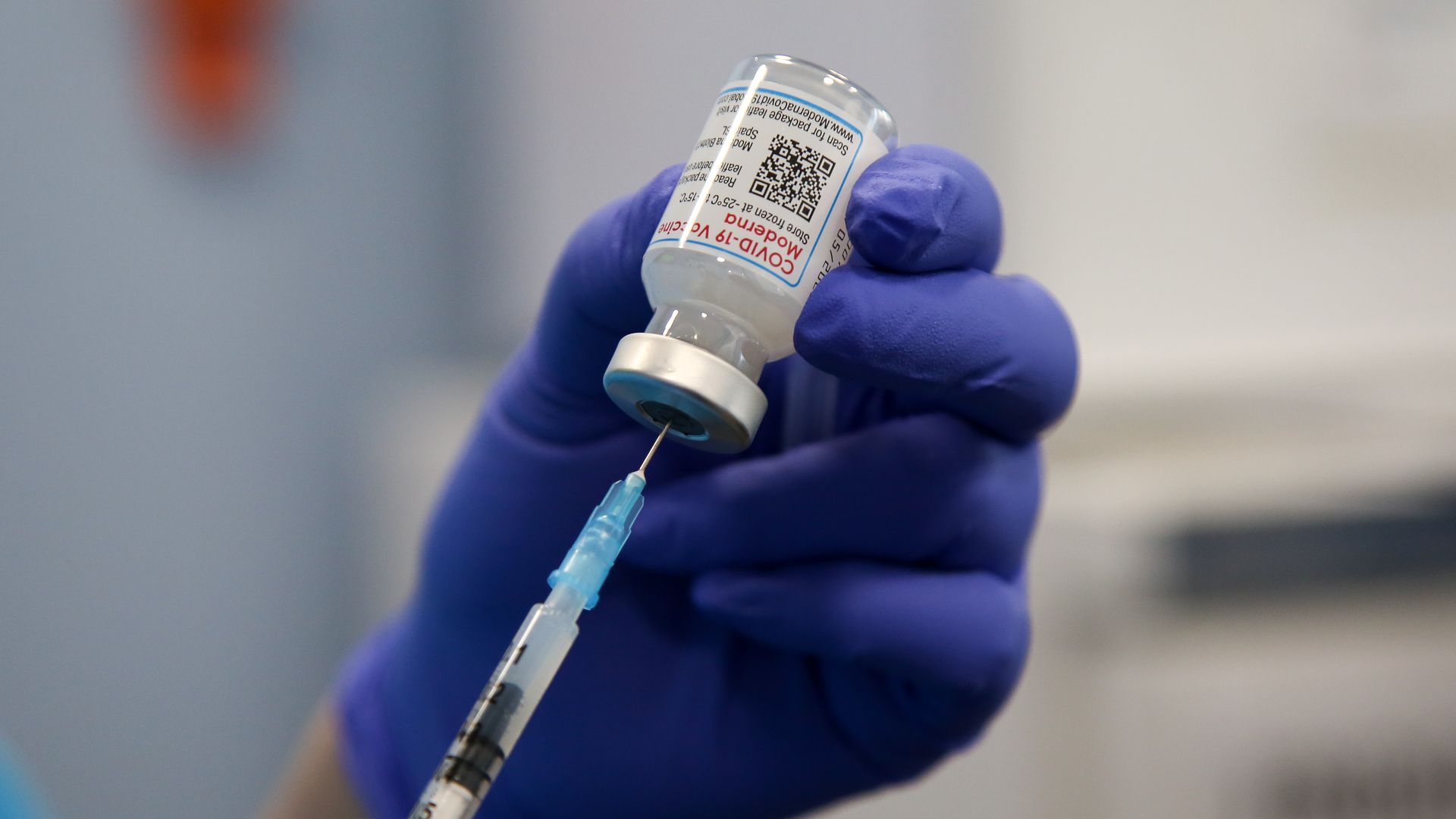 A health worker draws the Moderna COVID-19 vaccine as she prepares to administer the spring booster also known as fourth jab to a person at a vaccination clinic