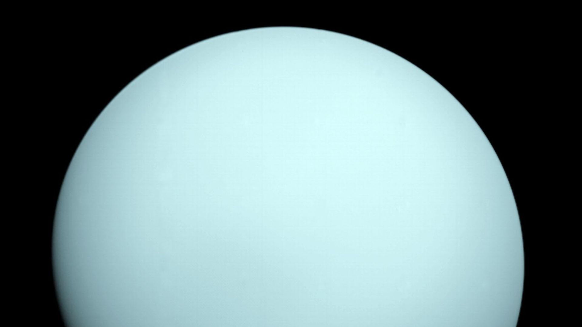 Uranus in pale blue seen by Voyager 2