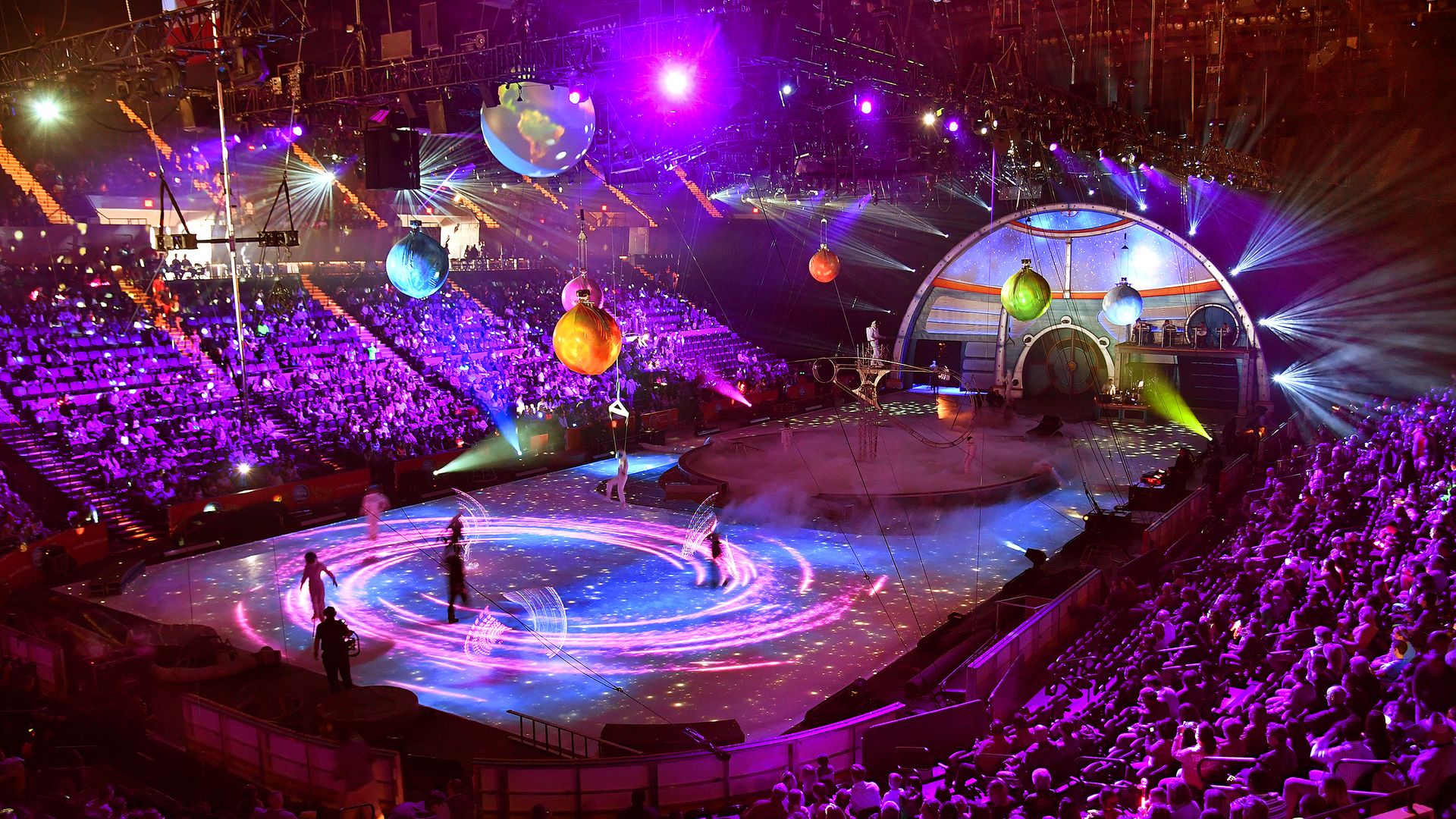 The final performance of the Ringling Bros. and Barnum & Bailey circus in 2017, with swirling movement in the center and planet-like decor hanging from the venue.