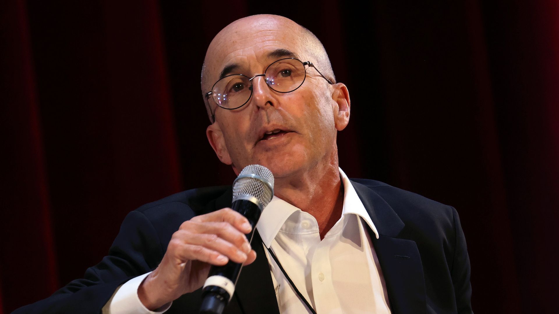Author Don Winslow holds a microphone.