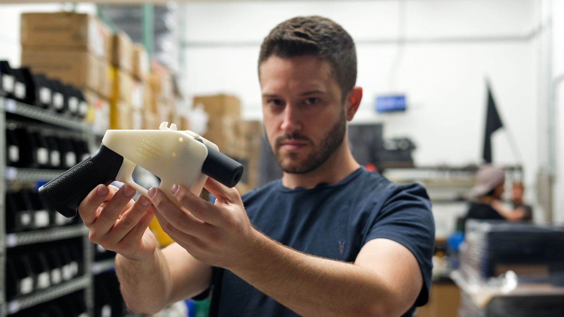 Owner of Defense Distributed holding a 3D-printed gun