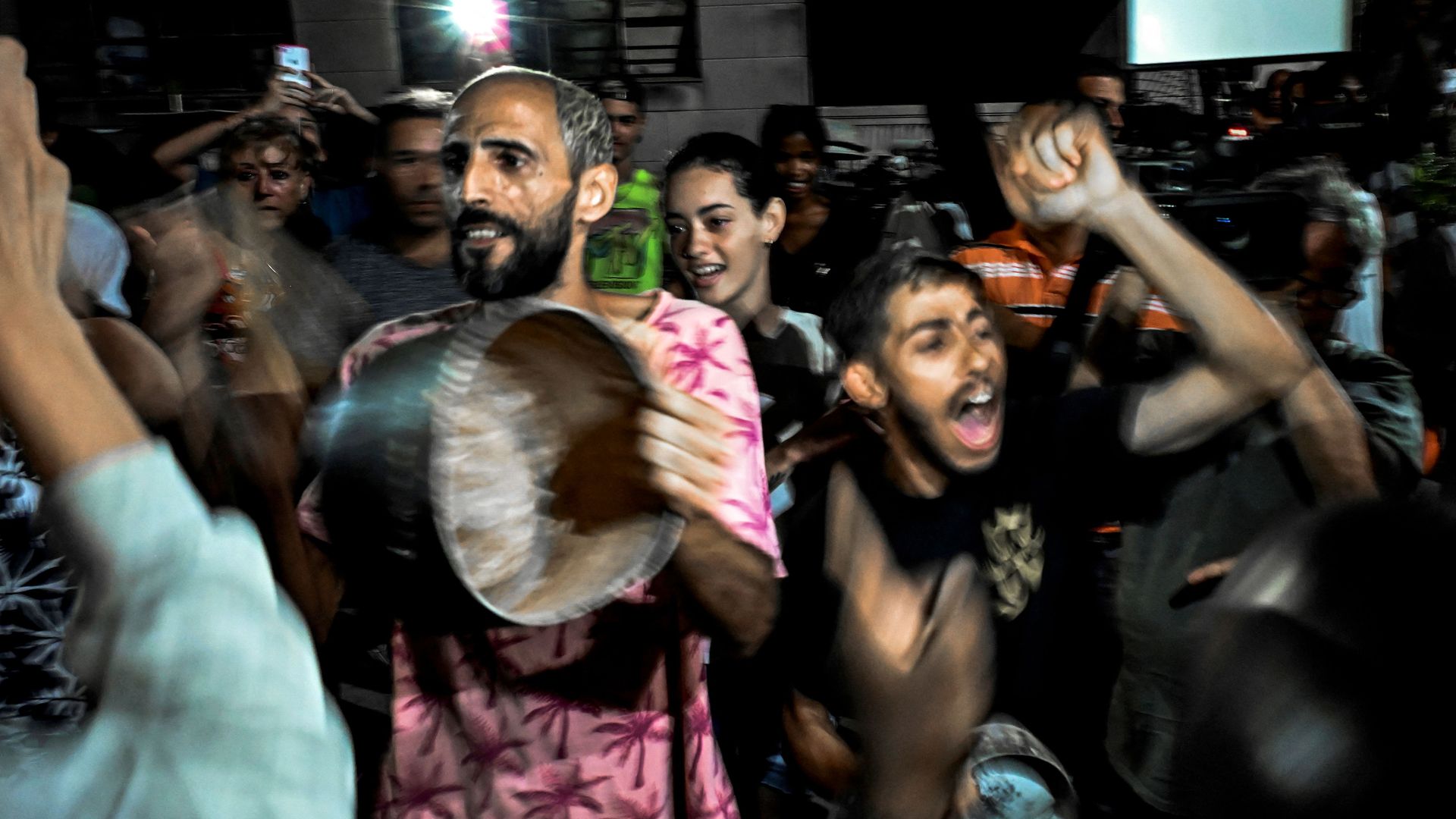 people protest and chant in the street during a blackout in Cuba 