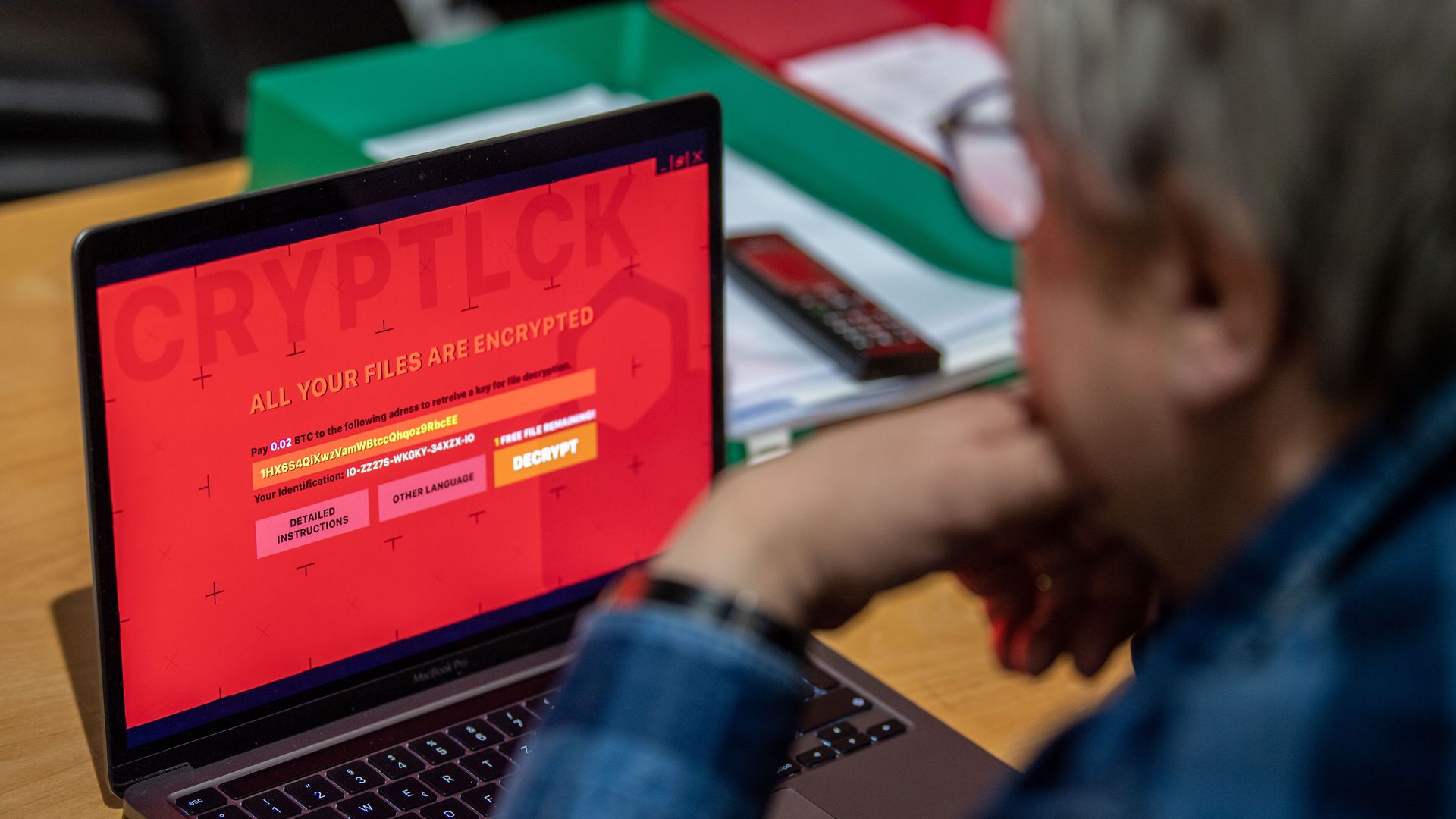 Image of a man with a laptop encrypted with ransomware