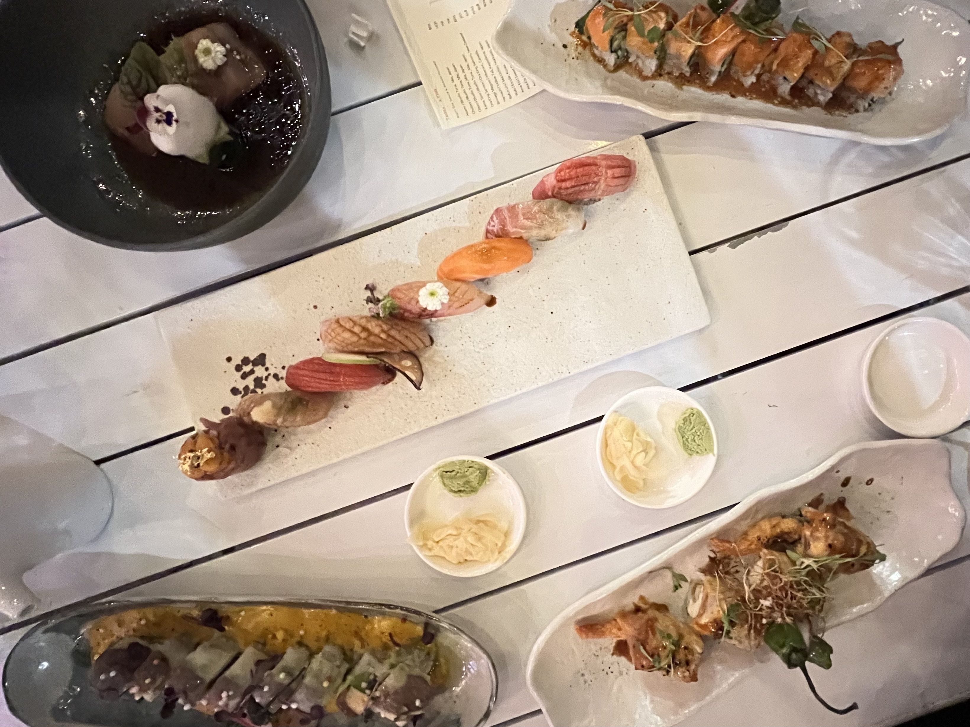 Plates of sushi arranged on a white table.