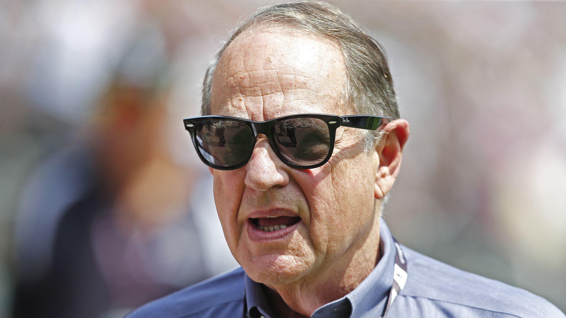 Photo of a man wearing sunglasses at a stadium. 