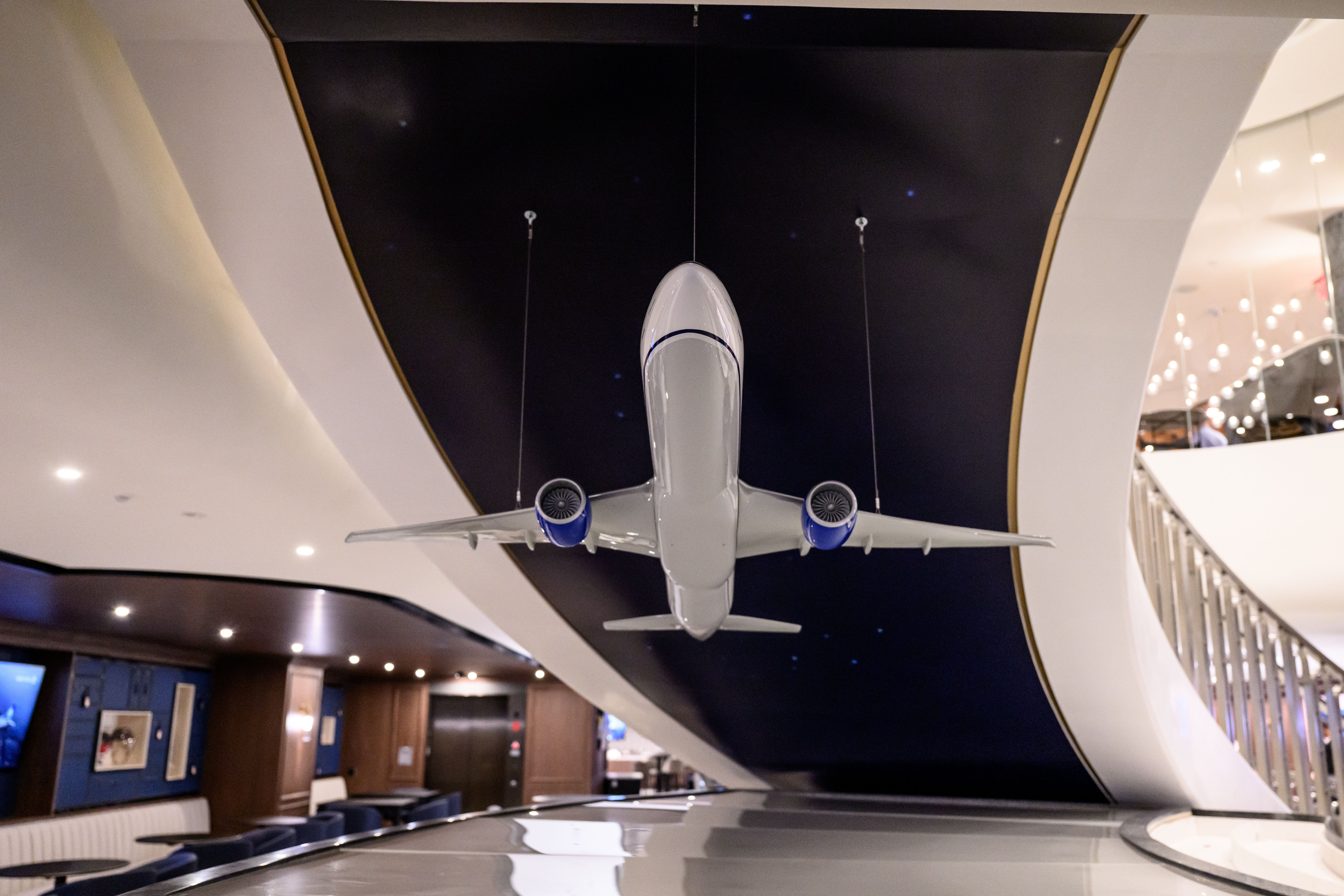A model airplane hangs from a black and white ceiling