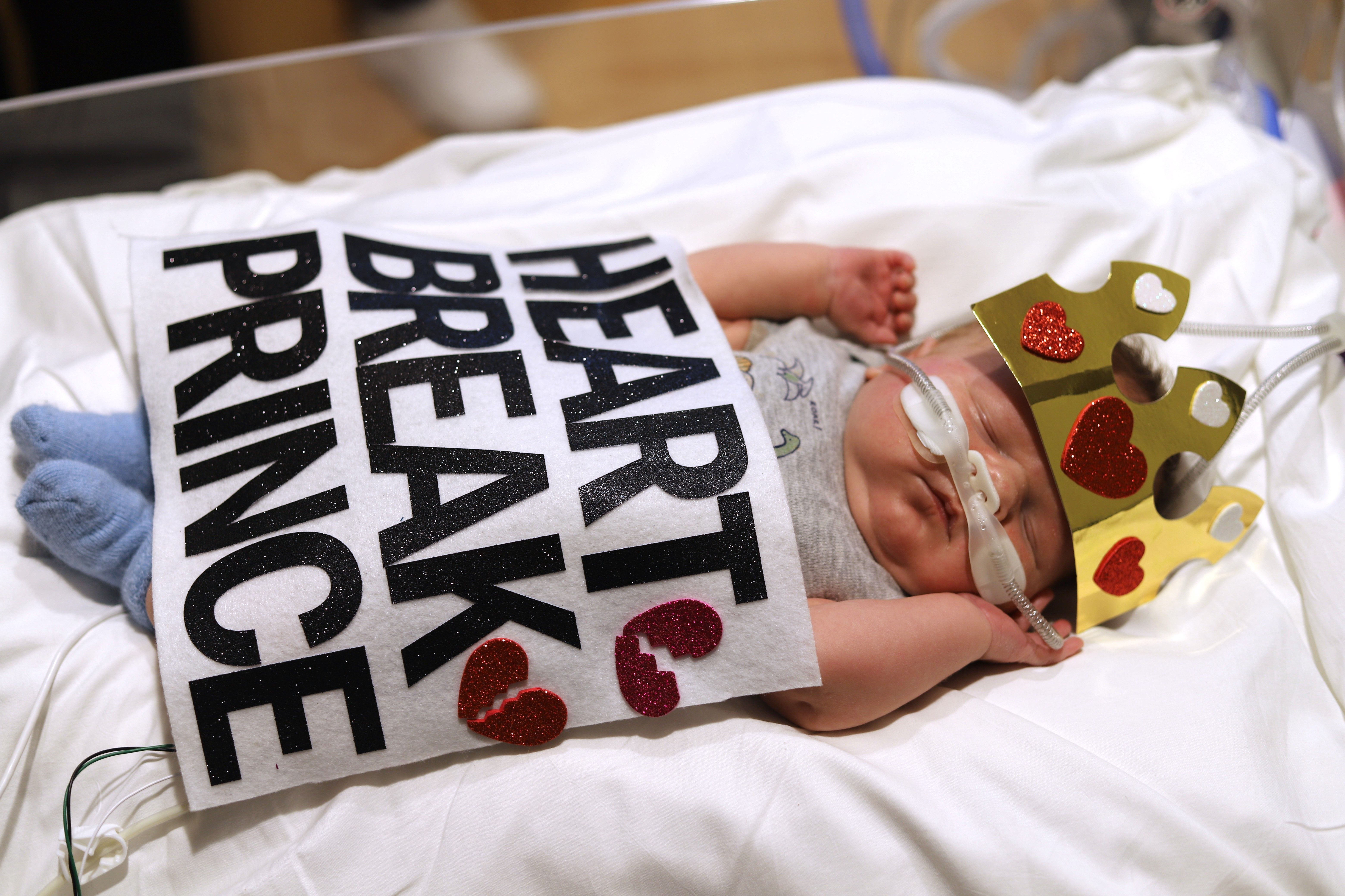 Image shows a baby in a costume that says "Heartbreak Prince."