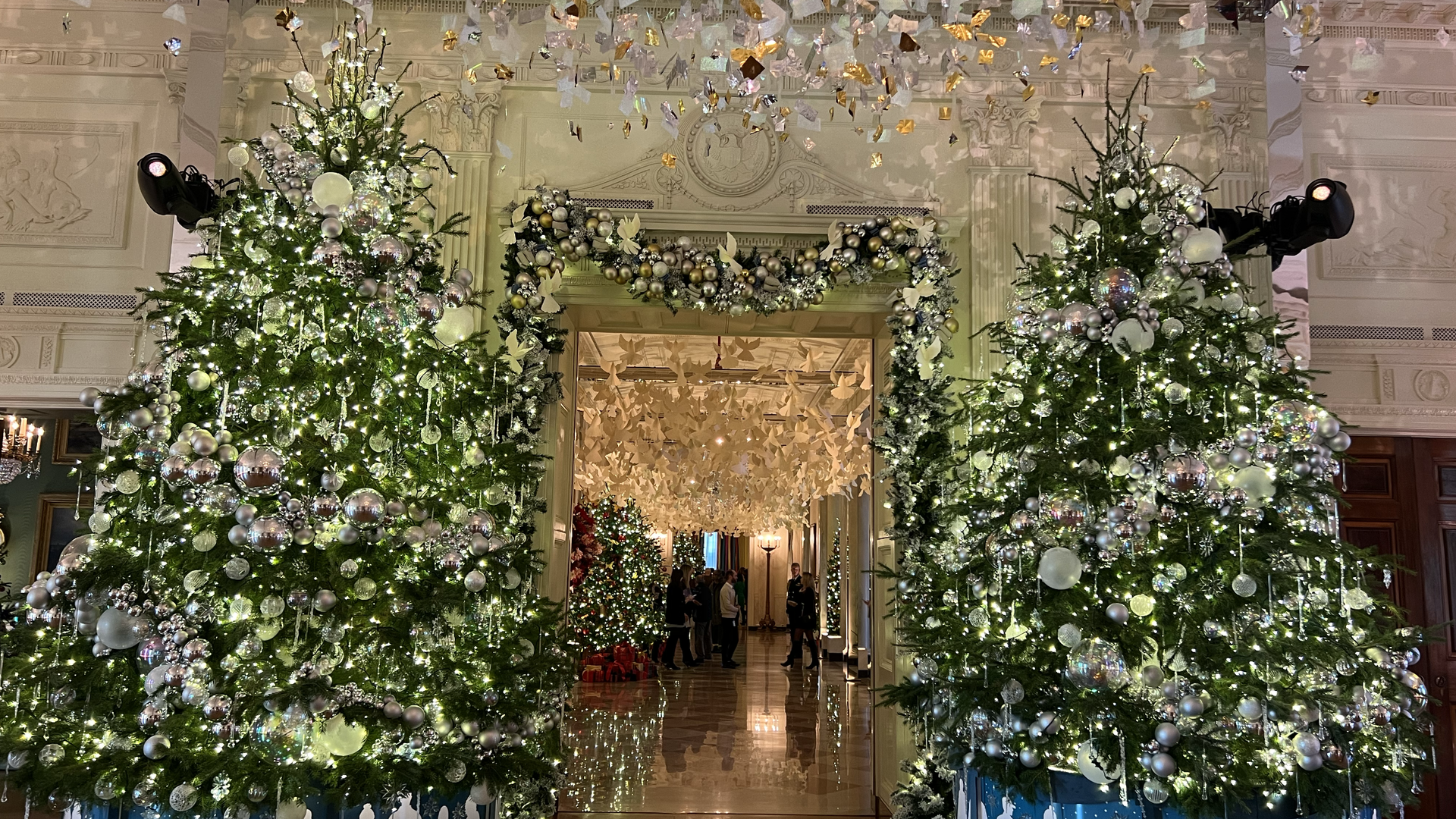 Two large Christmas trees in the White House's East Room.