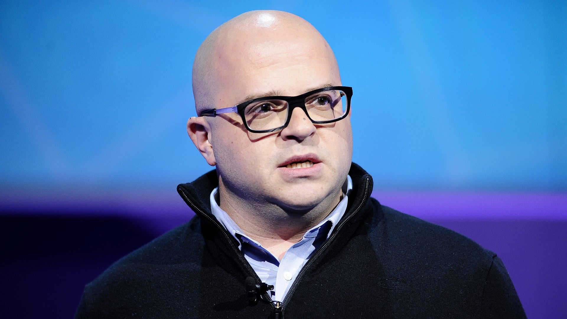 Jeff Lawson, founder, CEO and chairman of Twilio talking on a stage with blue back lighting