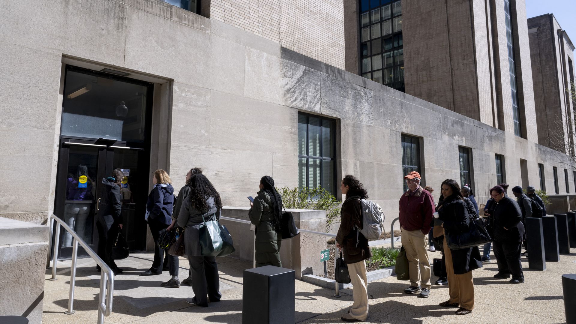 Federal workers wait in line to access to the Mary E. Switzer Memorial Building that houses the US Department of Health and Human Services in D.C. on April 1.