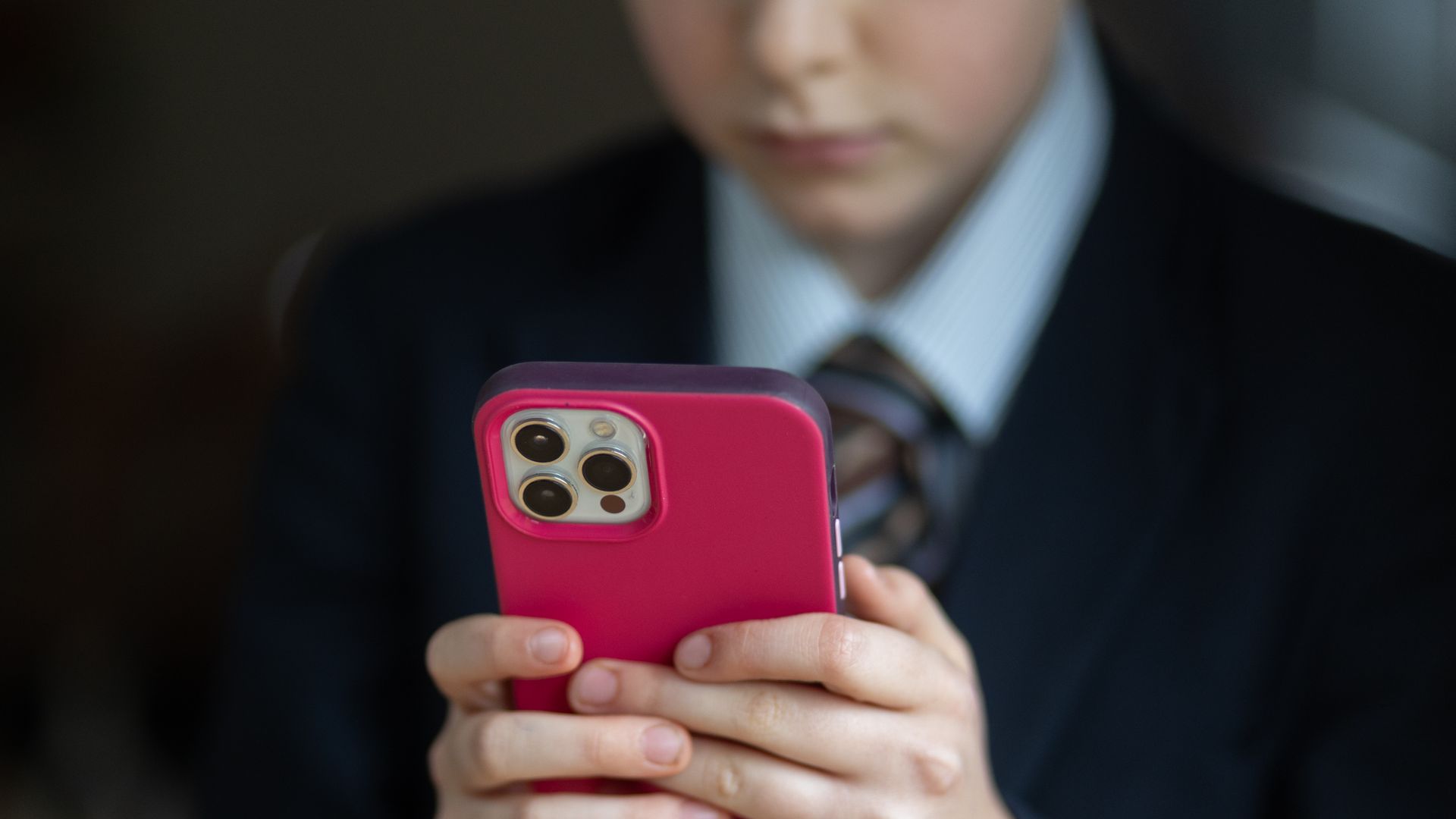  In this photo illustration a a 12-year-old school boy looks at a iPhone screen.