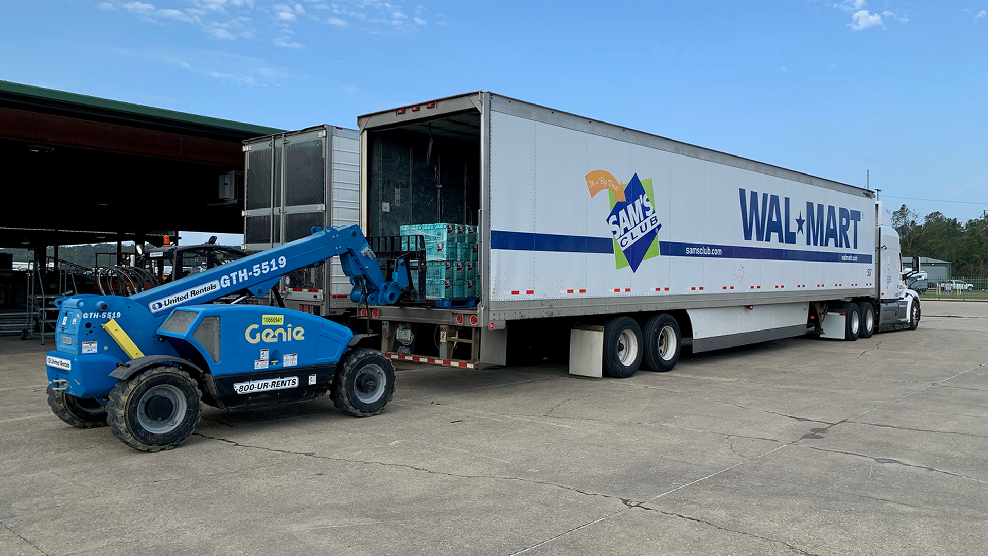 A forklift loads a Walmart truck with supplies. 