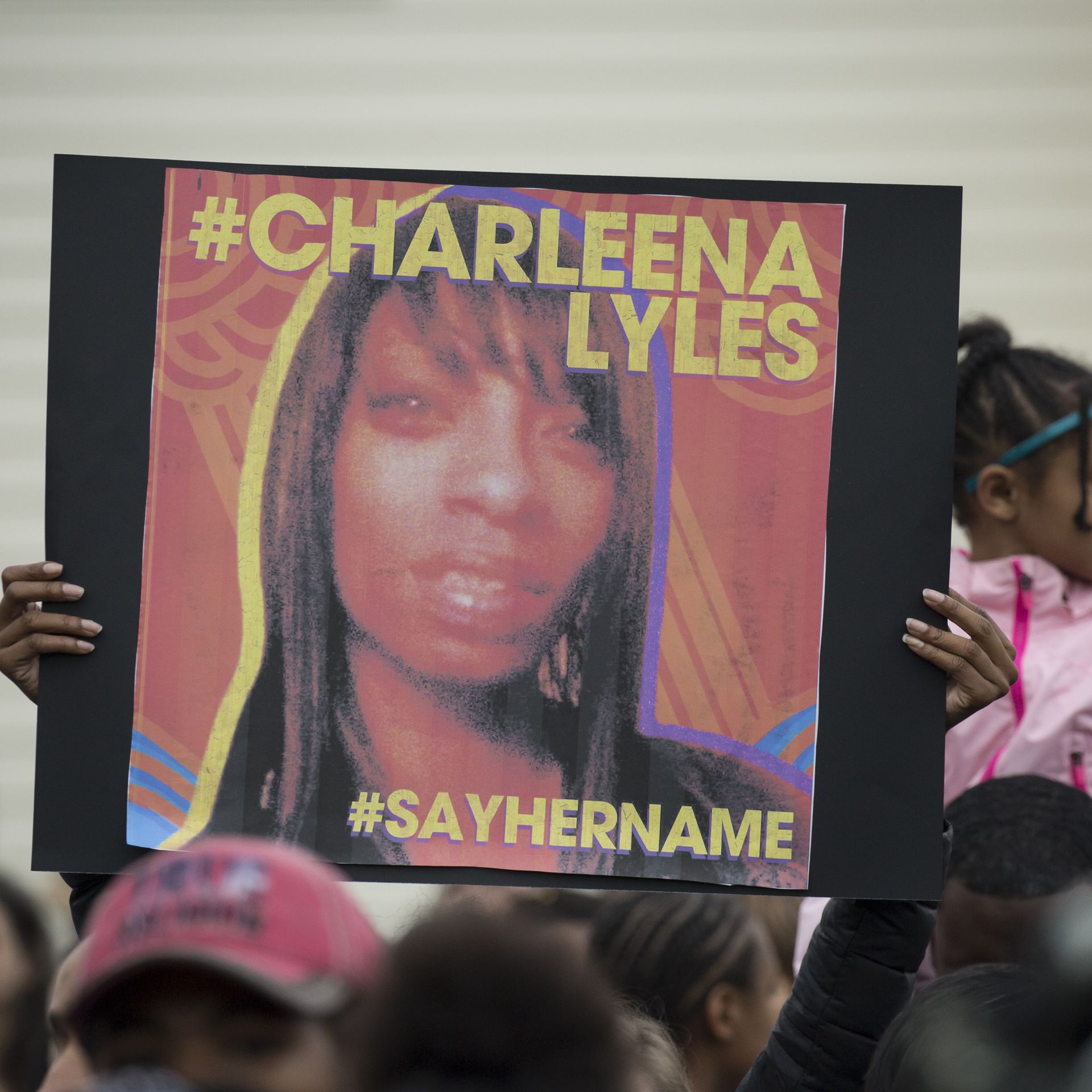A protester holds a sign with an image of Charleena Lyles